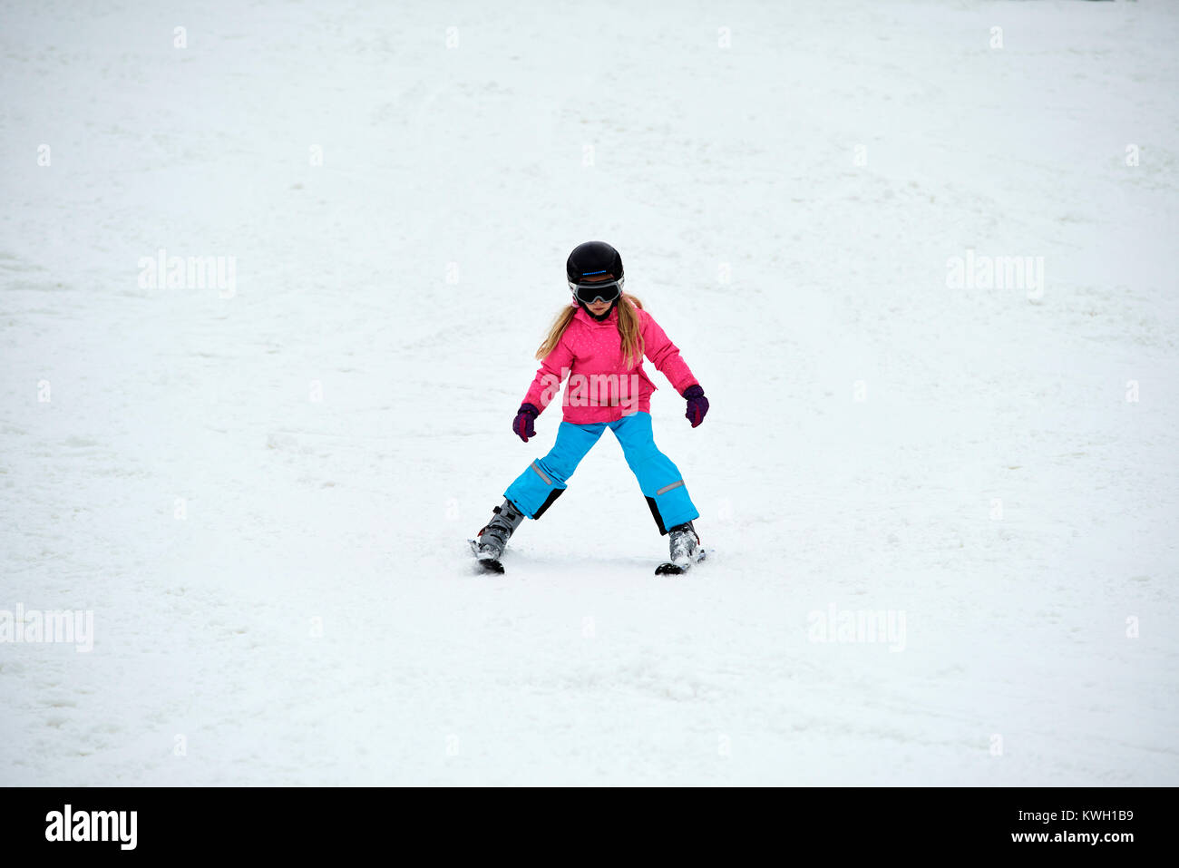 Niña en las pistas de esquí con cascos y gafas de esquí Fotografía de stock  - Alamy