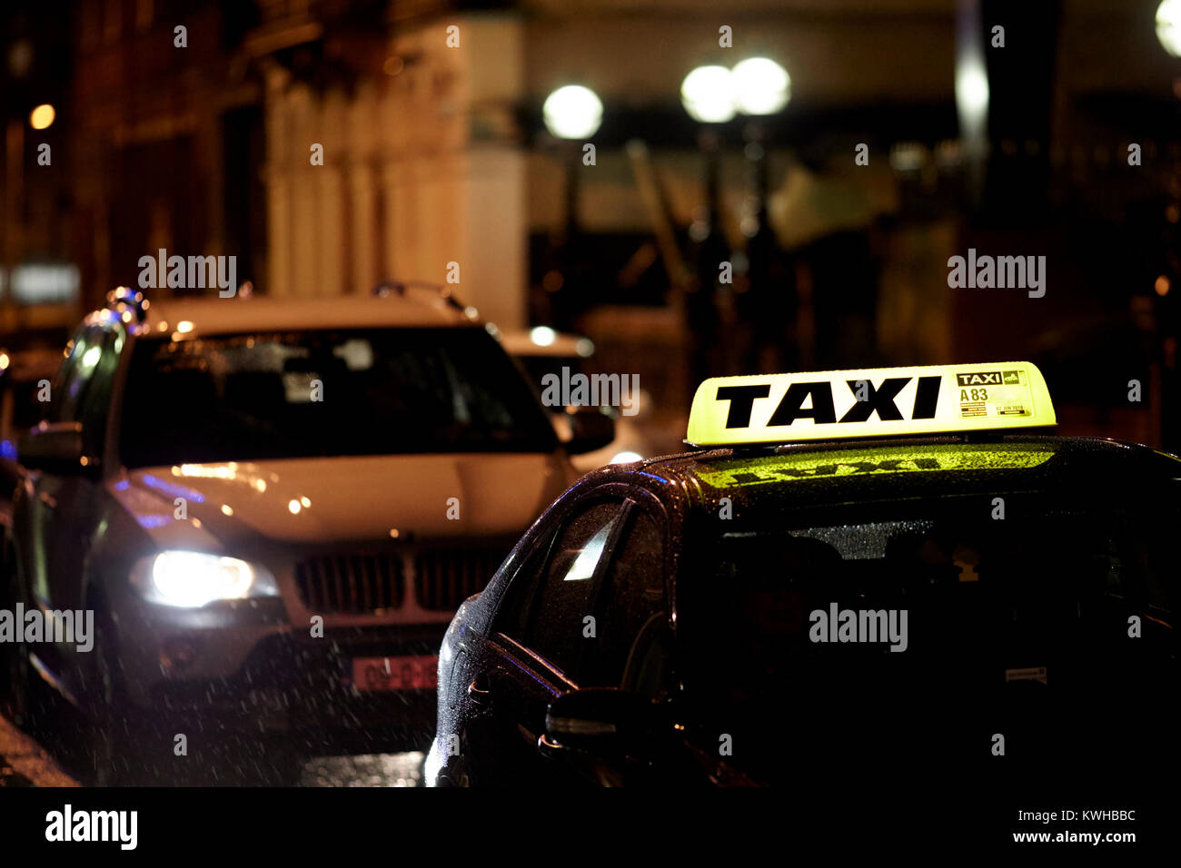 Taxi privado sentado en la lluvia en un centro de la ciudad de Belfast, Irlanda del Norte, reino unido Foto de stock