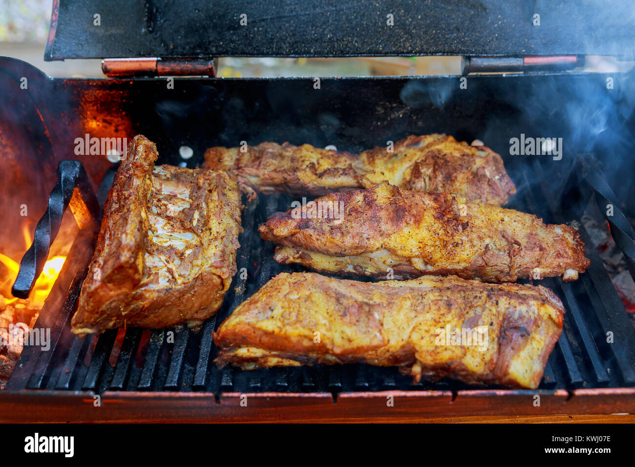 Costillas de cerdo a la parrilla sobre un fuego de madera baby back ribs de  cerdo cocinado en flaming grill Fotografía de stock - Alamy
