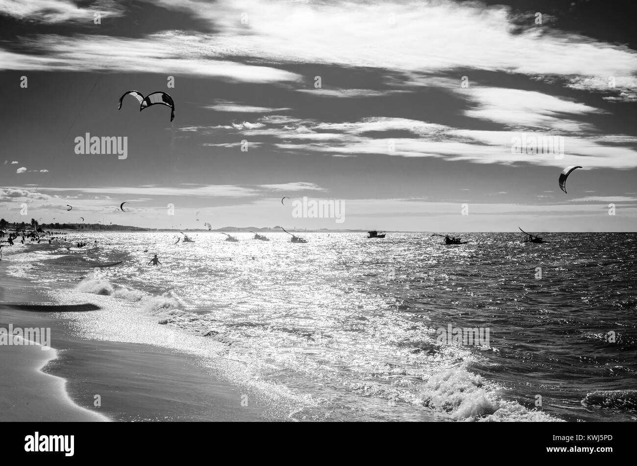 Puesta de sol en blanco y negro con kite surf disfrutando del mar al atardecer Foto de stock