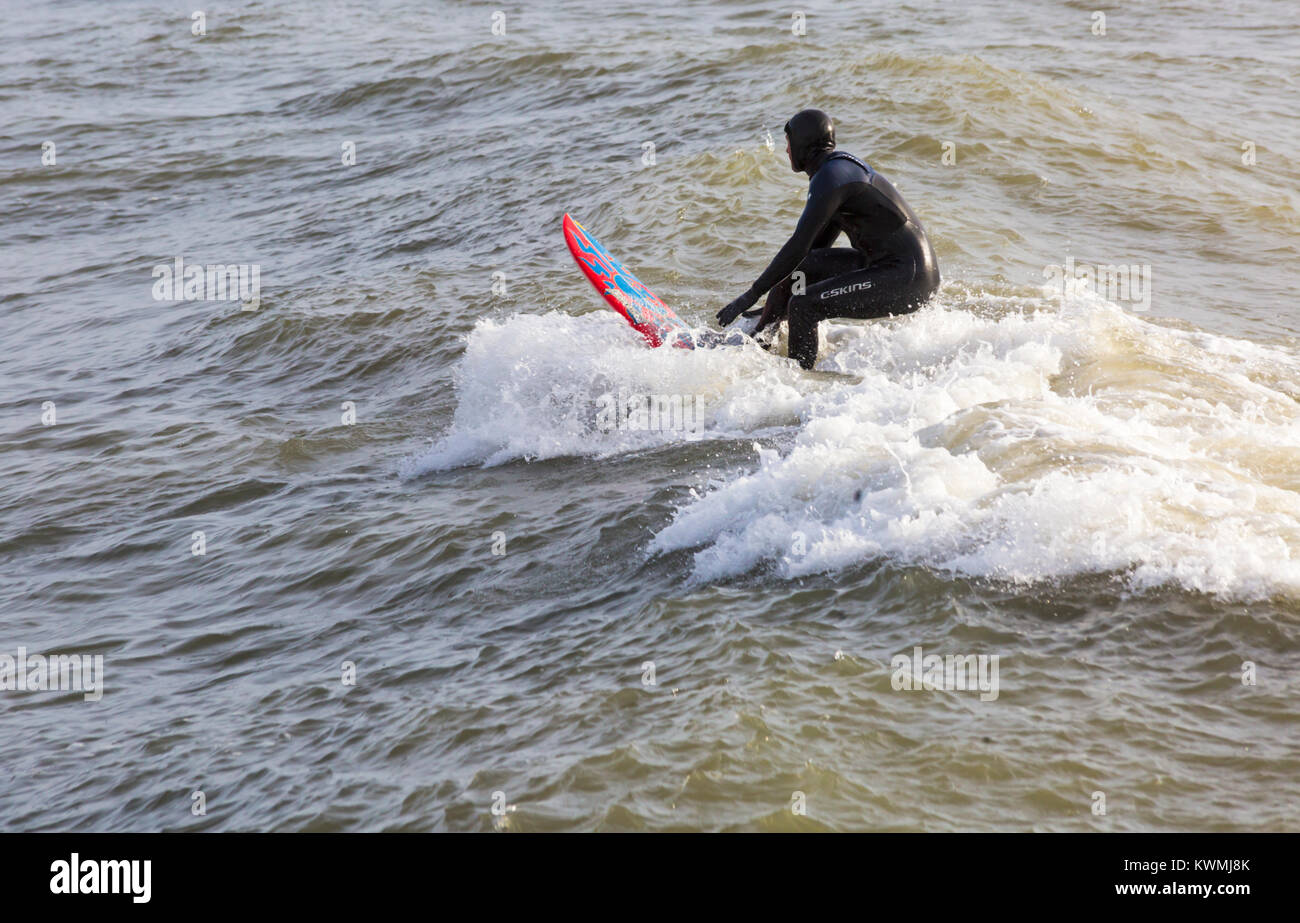 Bournemouth, Dorset, Inglaterra. El 4 de enero, 2018. El clima del REINO UNIDO: surfer montando una onda disfrutando del surf en un día ventoso en Bournemouth beach, los surfistas hacen la mayoría de las condiciones de viento y olas grandes. Crédito: Carolyn Jenkins/Alamy Live News Foto de stock