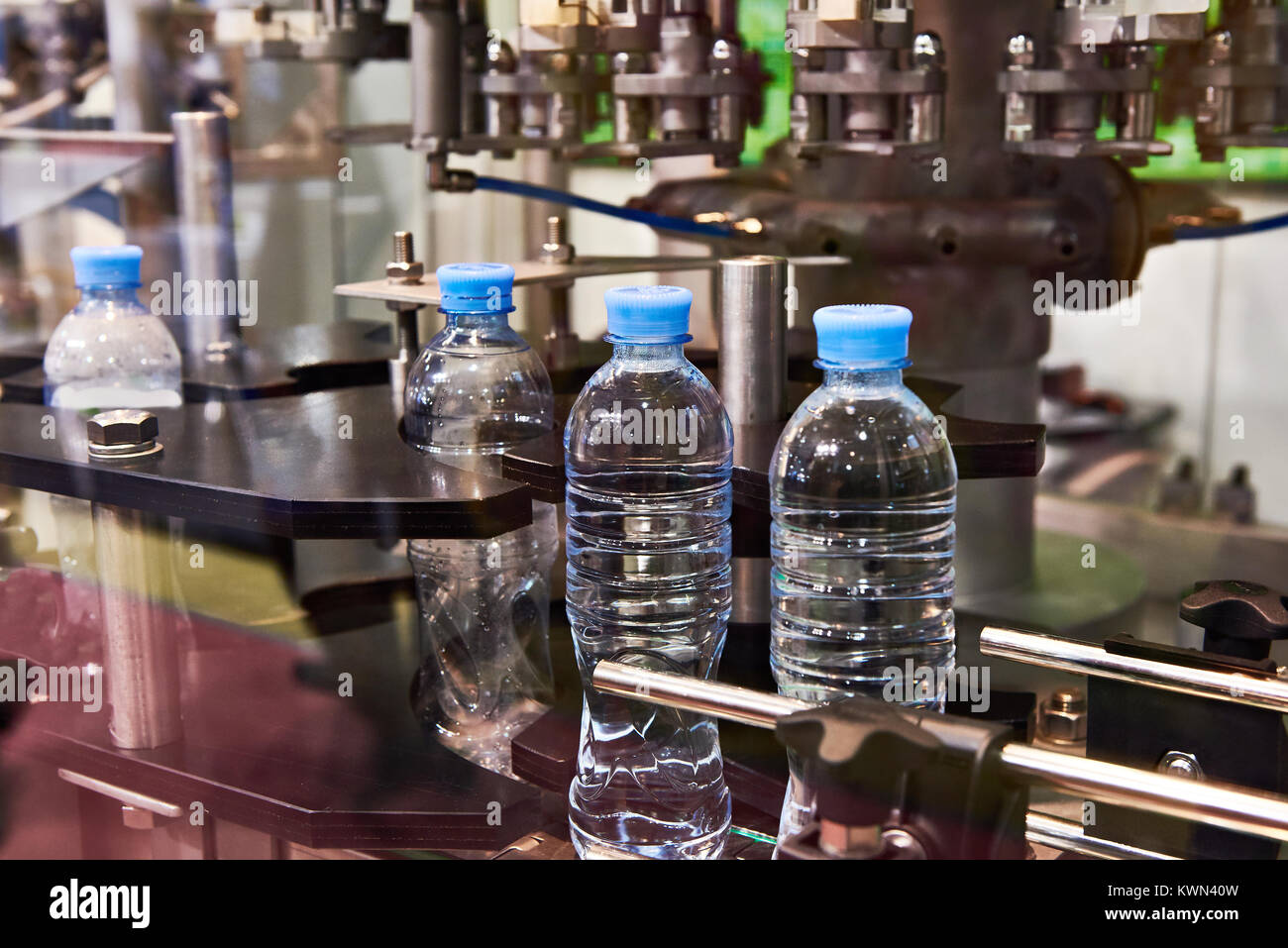 Línea de embotellado de bebidas en botellas de plástico de fábrica Foto de stock