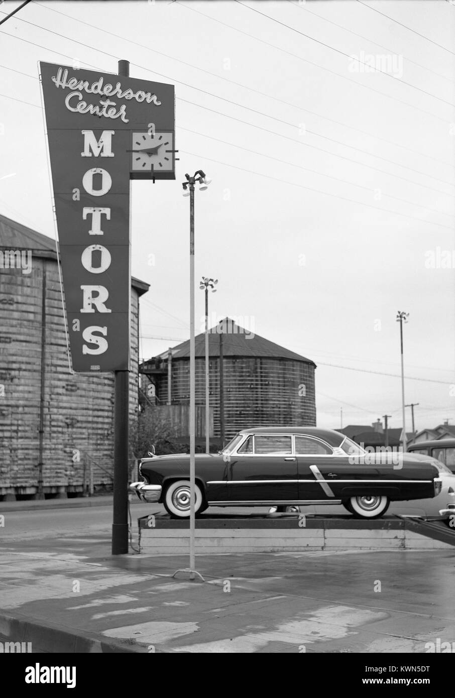 Señalización para Henderson Centro Motors, un concesionario de coches en Eureka, California, con silos y un nuevo Lincoln Capri visible del automóvil, Eureka, California, en 1950. Foto de stock