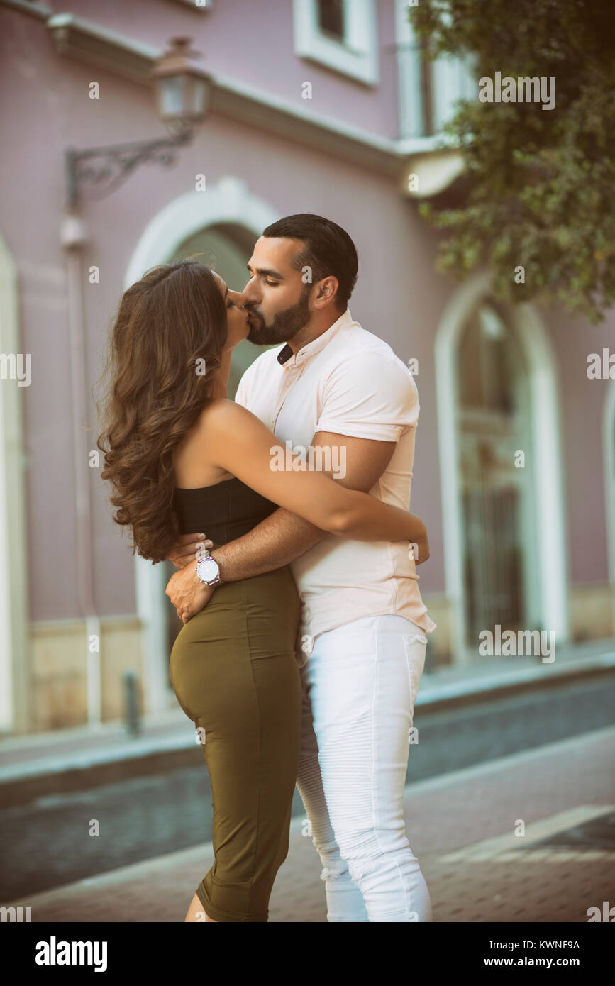 Pareja sonriente en el amor en un columpio al aire libre, hombre bese su  frente de mujer Fotografía de stock - Alamy