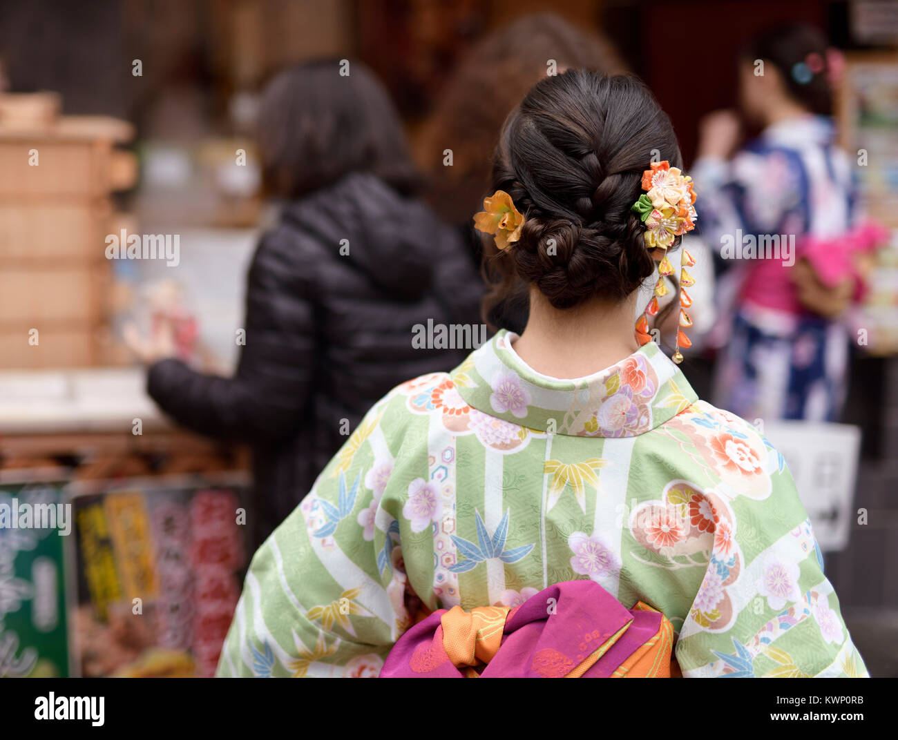 Niña japonesa en un colorido kimono yukata con un lindo peinado cabello colorido e intrincado ornamento Kanzashi, vista trasera closeup. Kyoto, Japón. Foto de stock