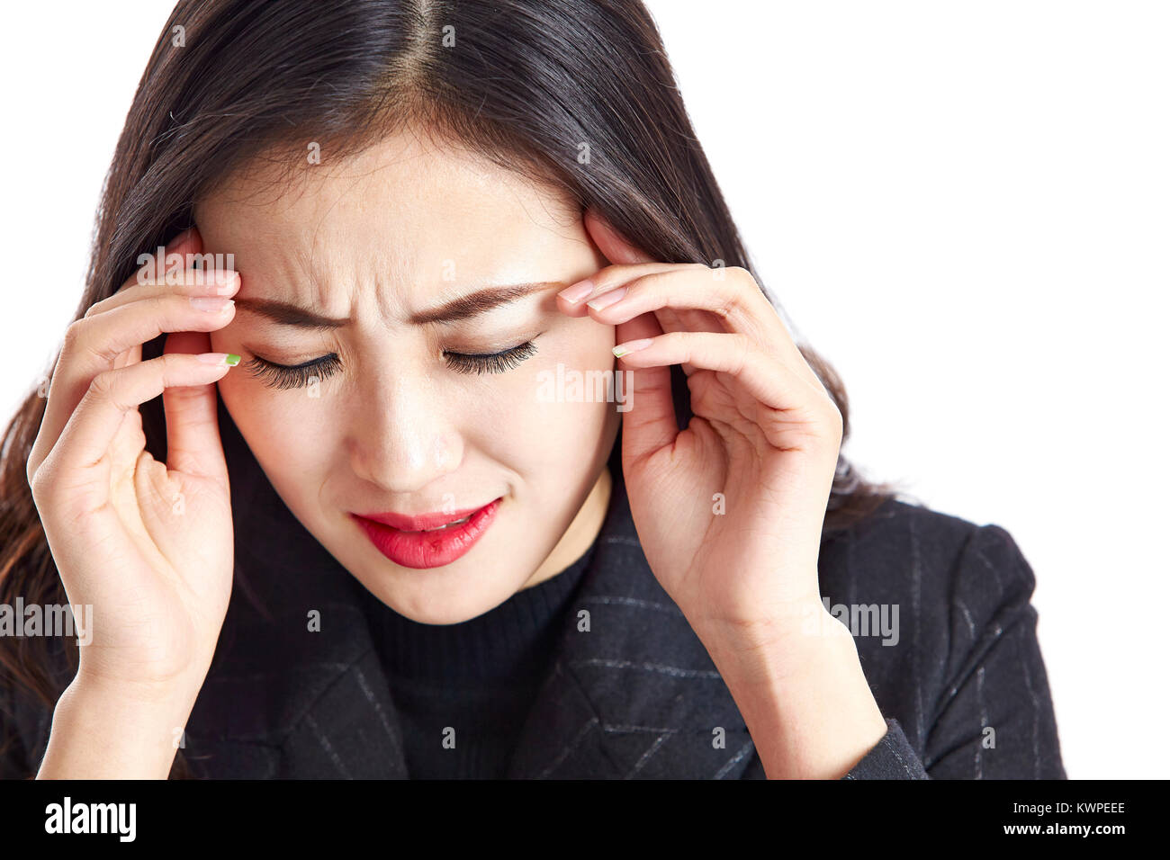Foto de estudio de una joven mujer de negocios asiáticos tener un dolor de cabeza, dolor y miserables, con la mano en el templo, aislado sobre fondo blanco. Foto de stock