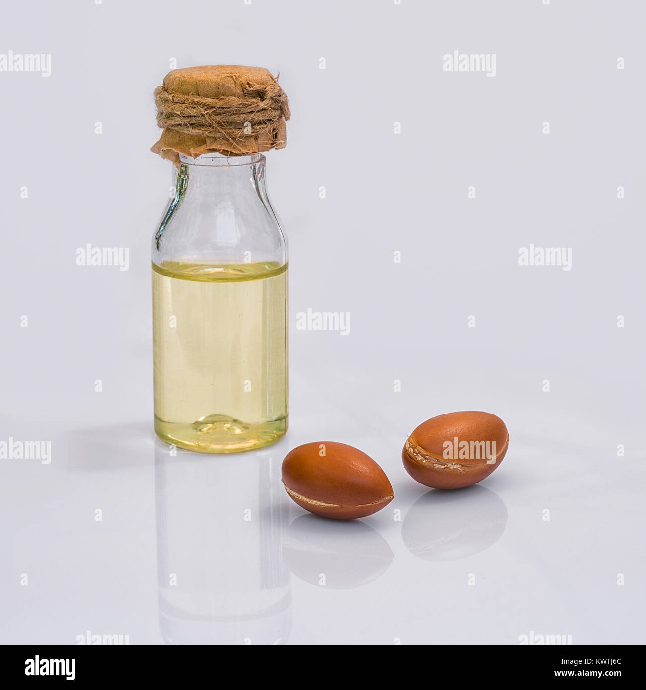Fruto de argán (Argania spinosa), frutos secos y aceite sobre fondo