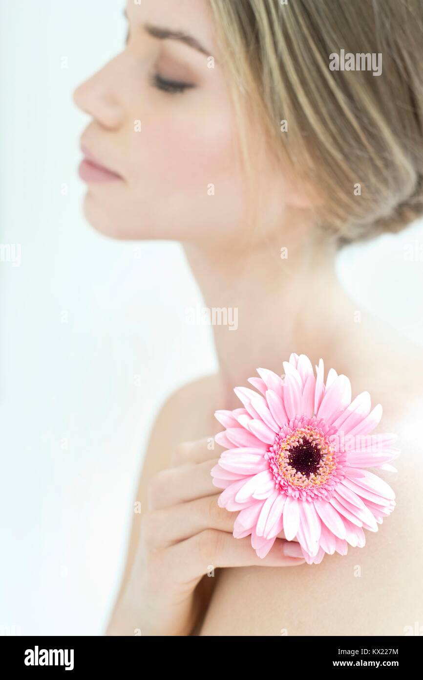 Modelo liberado. Mujer joven sosteniendo la flor, retrato. Foto de stock