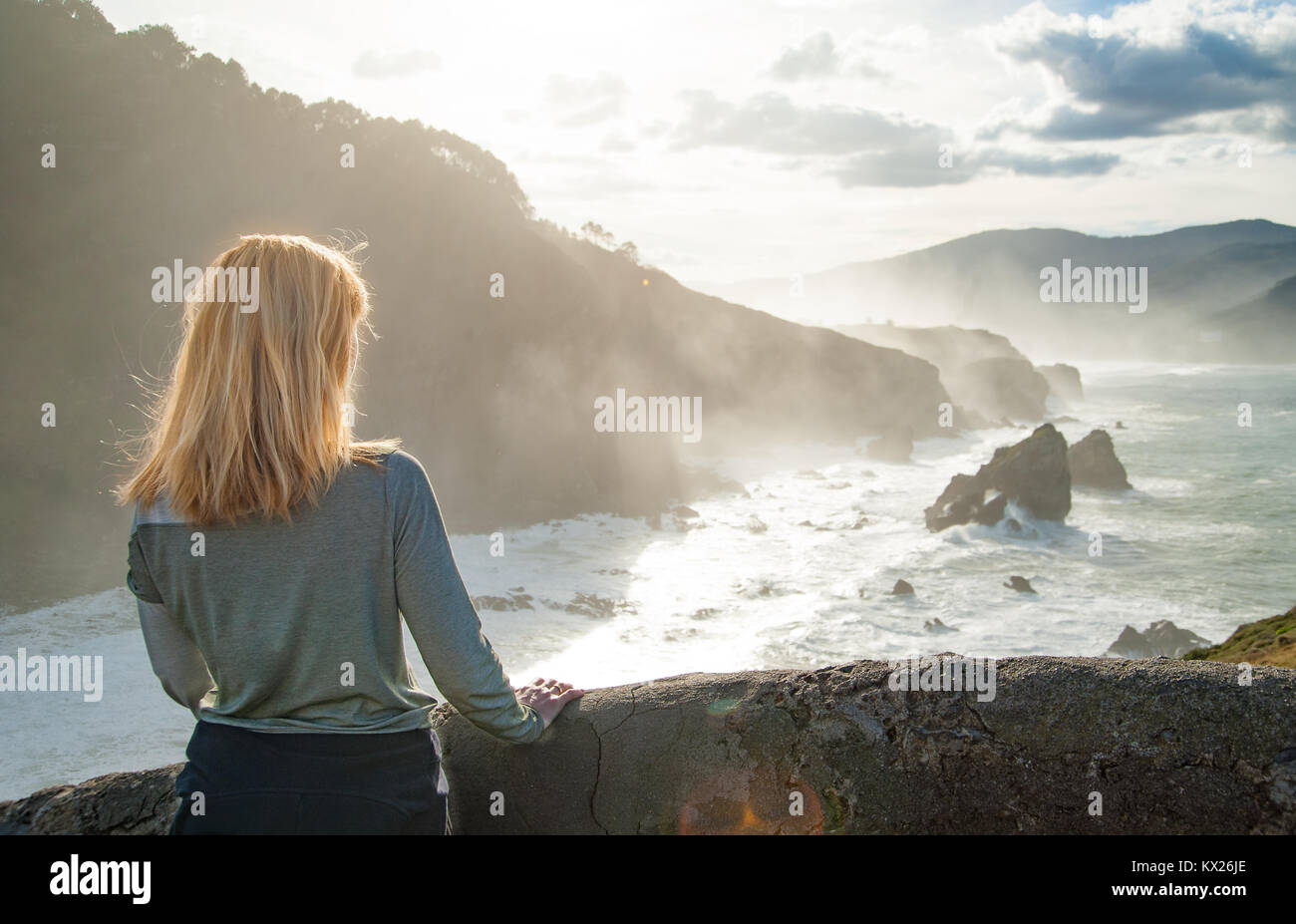 Una fianza mujeres en ropa deportiva observando una marea escénica en costa  rocosa con un pulverizador de agua , grandes olas aplastamiento Fotografía  de stock - Alamy