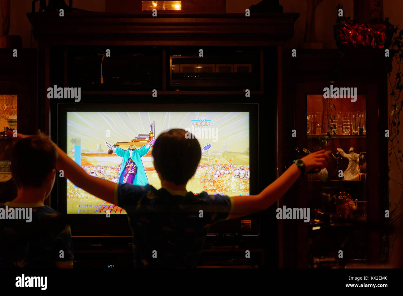 Un joven (9 años) bailando en frente de la TV para la PlayStation 4 Juego Just Dance Foto de stock