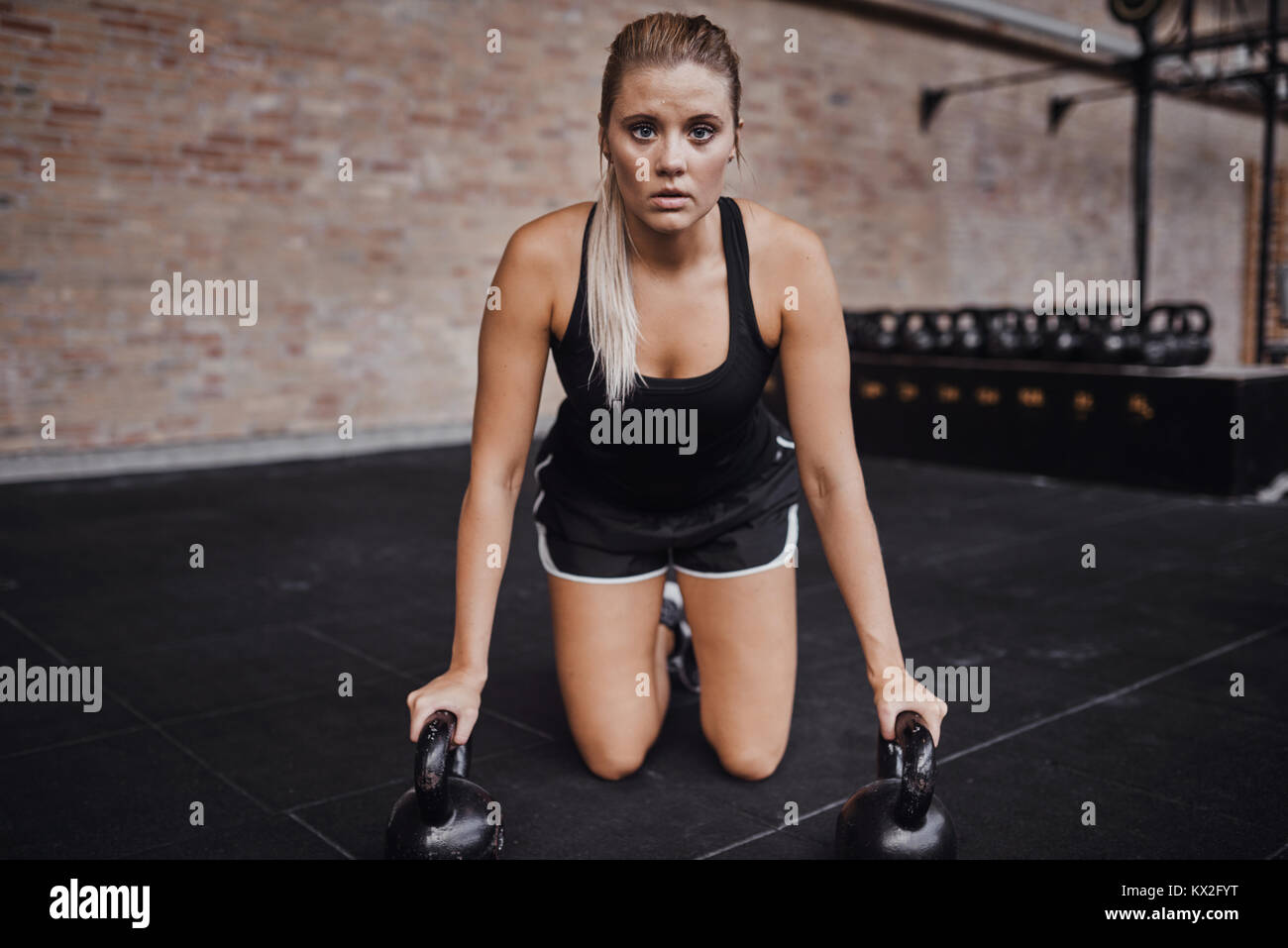 Mujer joven rubia centrada en ropa para hacer ejercicio El ejercicio solo  con pesas en el gimnasio Fotografía de stock - Alamy