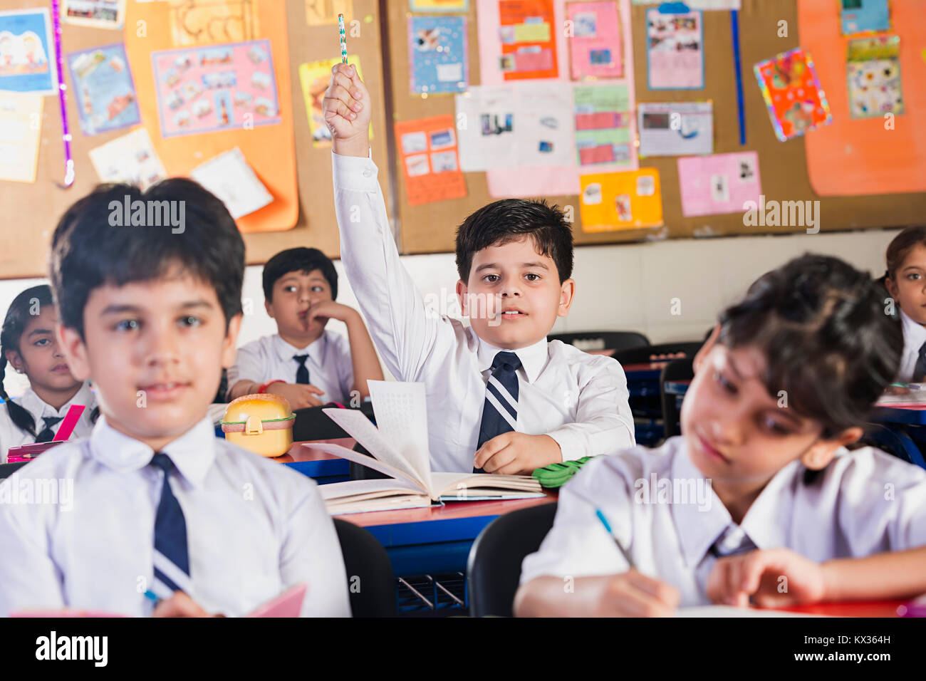 Los estudiantes que estudian en la Escuela India de clase y mano levantada cuestionamiento Foto de stock