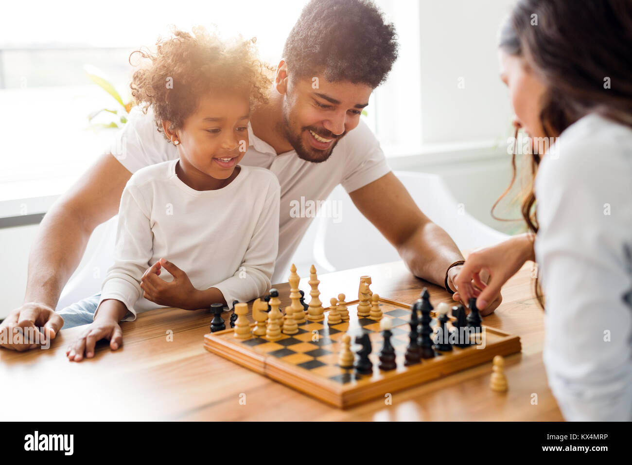 Familia feliz jugando ajedrez juntos Fotografía de stock - Alamy