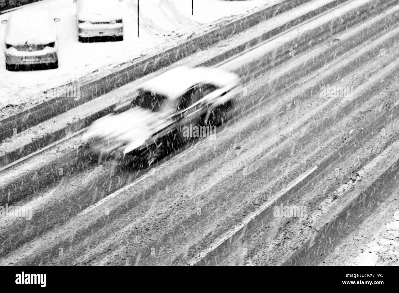 Coche borrosa sobre el vacío de las calles de la ciudad durante las fuertes nevadas Foto de stock