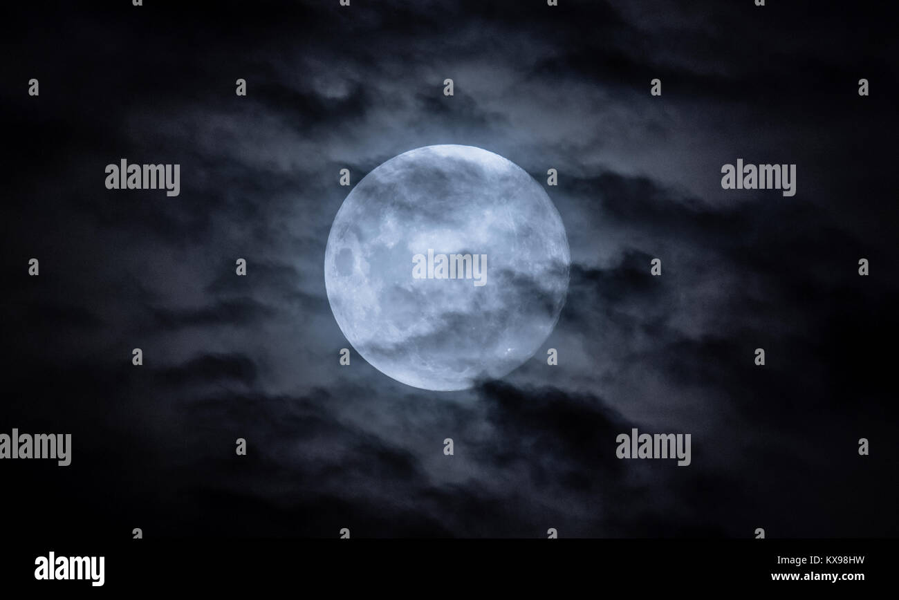 La luna llena en el cielo nocturno con nubes Foto de stock