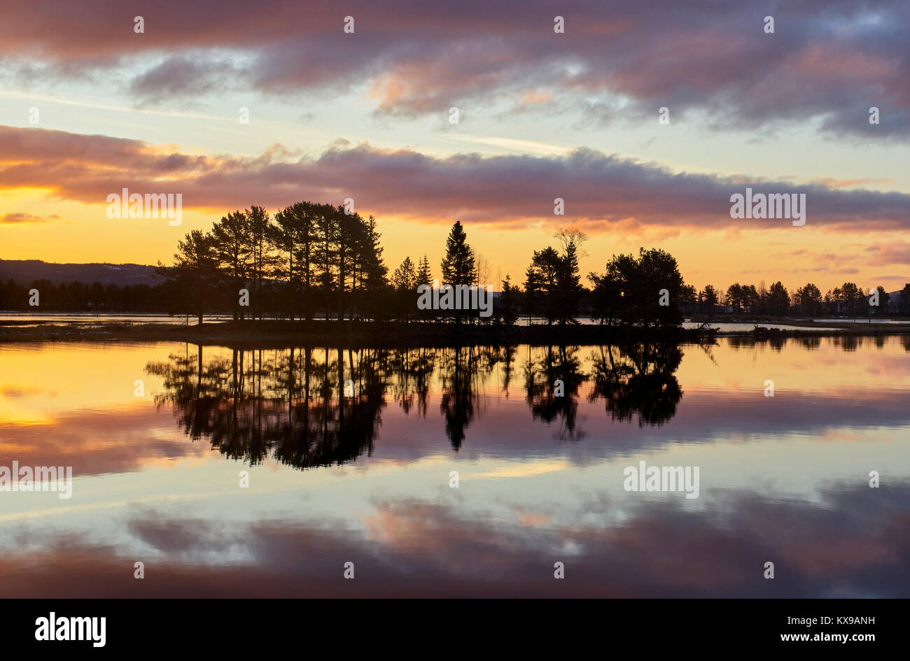 Amanecer sobre Osensjoen de Sandvik, Hedmark, Noruega. Imagen espejo reflejo Foto de stock