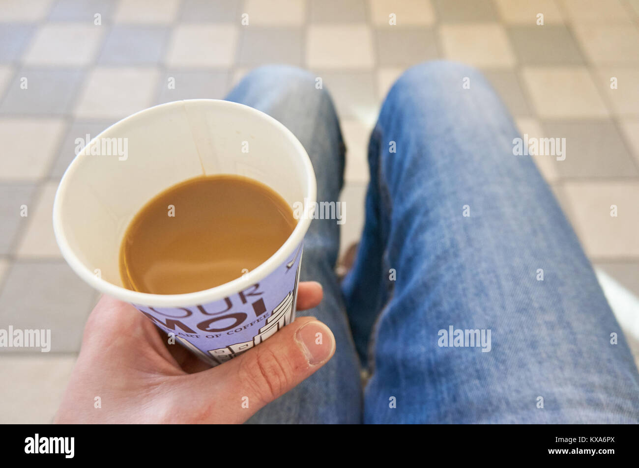 Hombre en una sala de espera con una taza de café blanco en su mano  Fotografía de stock - Alamy