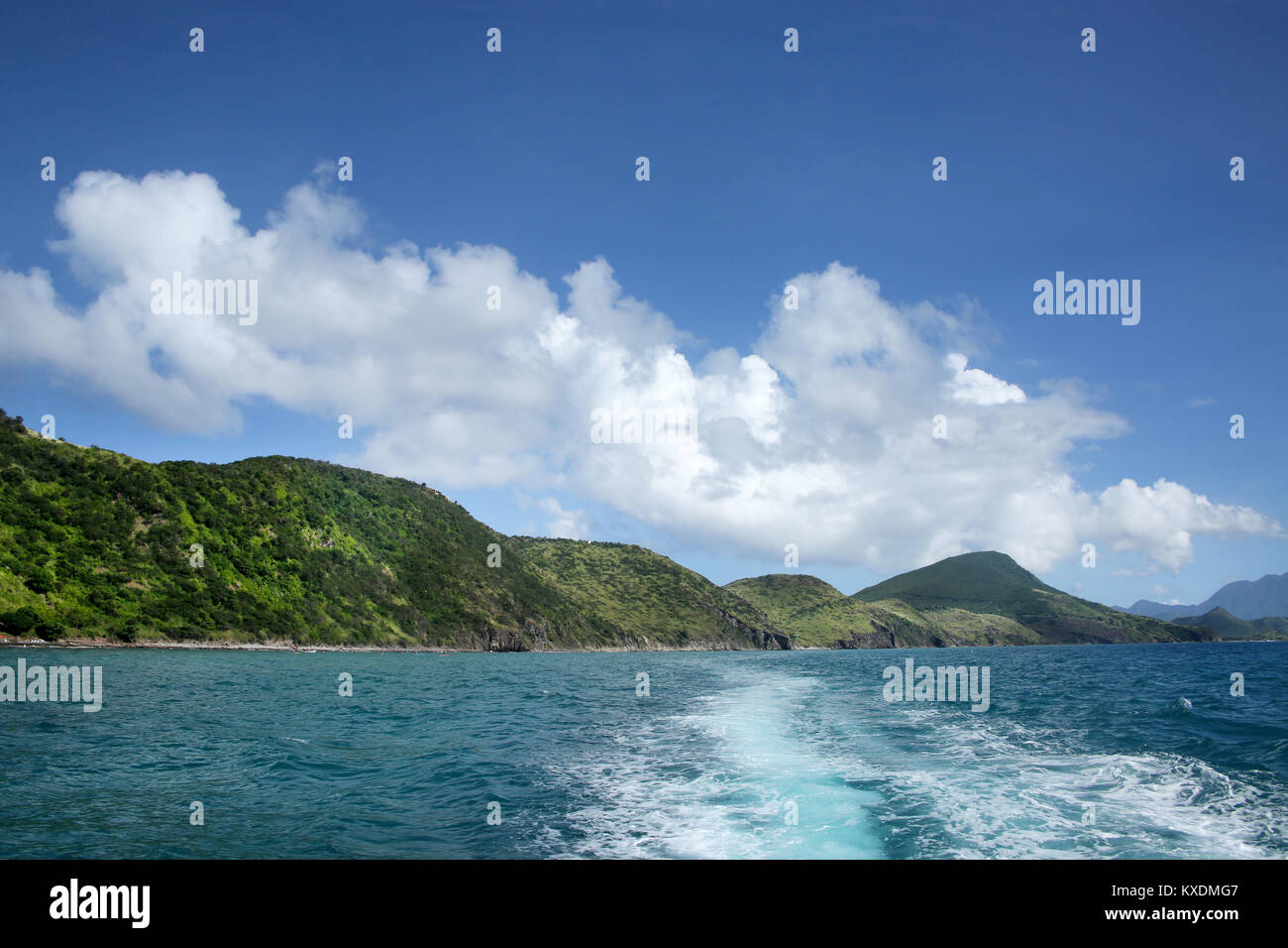 Vista de la costa desde el mar con la estela del barco, St Kitts, Caribe. Foto de stock