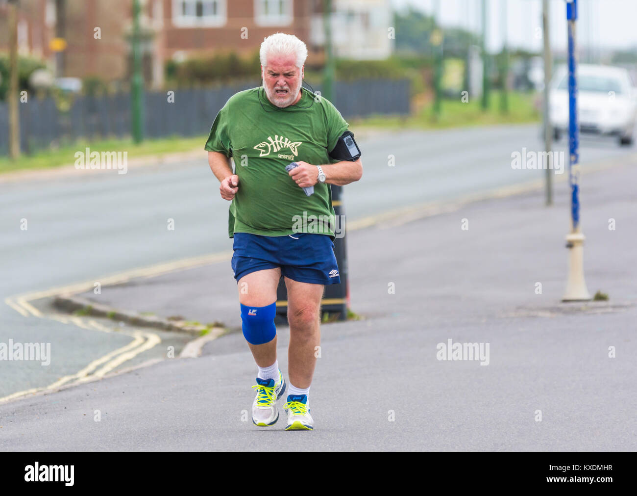 Hombre de mediana edad vistiendo un rastreador de fitness tiene un correr por la mañana. Foto de stock