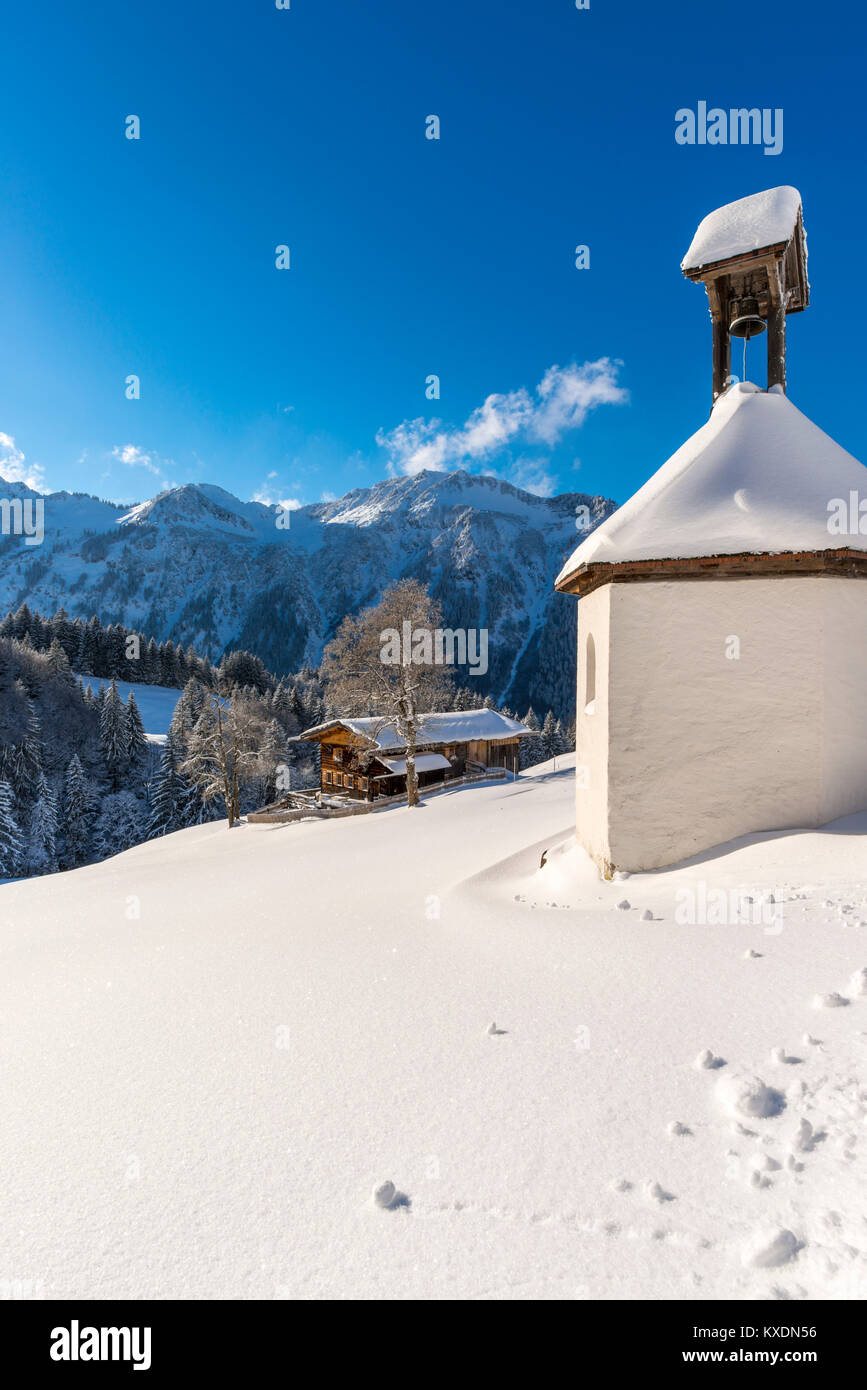 Granja de montaña y capilla en invierno, en Gerstruben, una antigua aldea de la agricultura de montaña en el valle cercano Dietersbach Oberstdorf Foto de stock