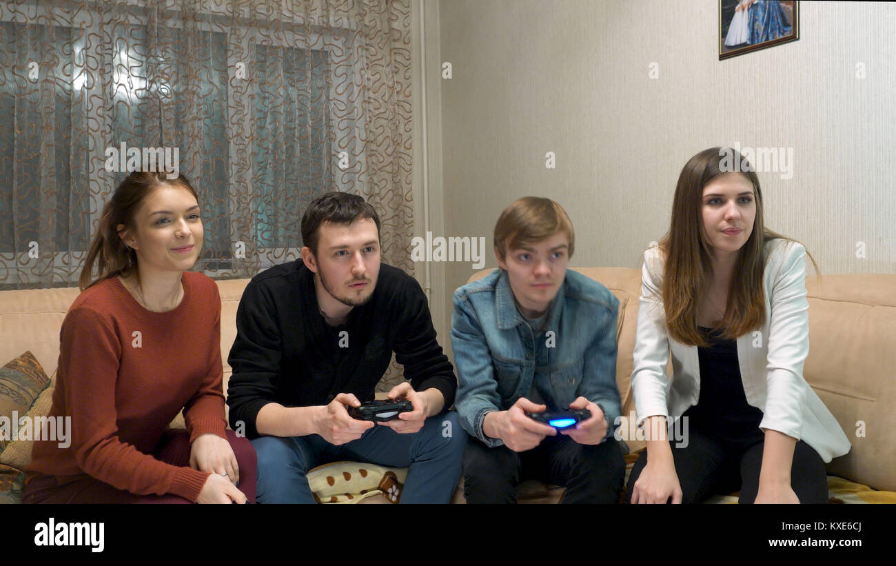 Dos parejas juego de consola. Un grupo de amigos, divertirse y jugar a videojuegos juntos. Emocionado amigos jugando juegos de video en casa Fotografía de stock - Alamy Dos parejas juego de consola. Un grupo de amigos, divertirse y jugar a videojuegos juntos. Emocionado amigos jugando juegos de video en casa Fotografía de stock - Alamy