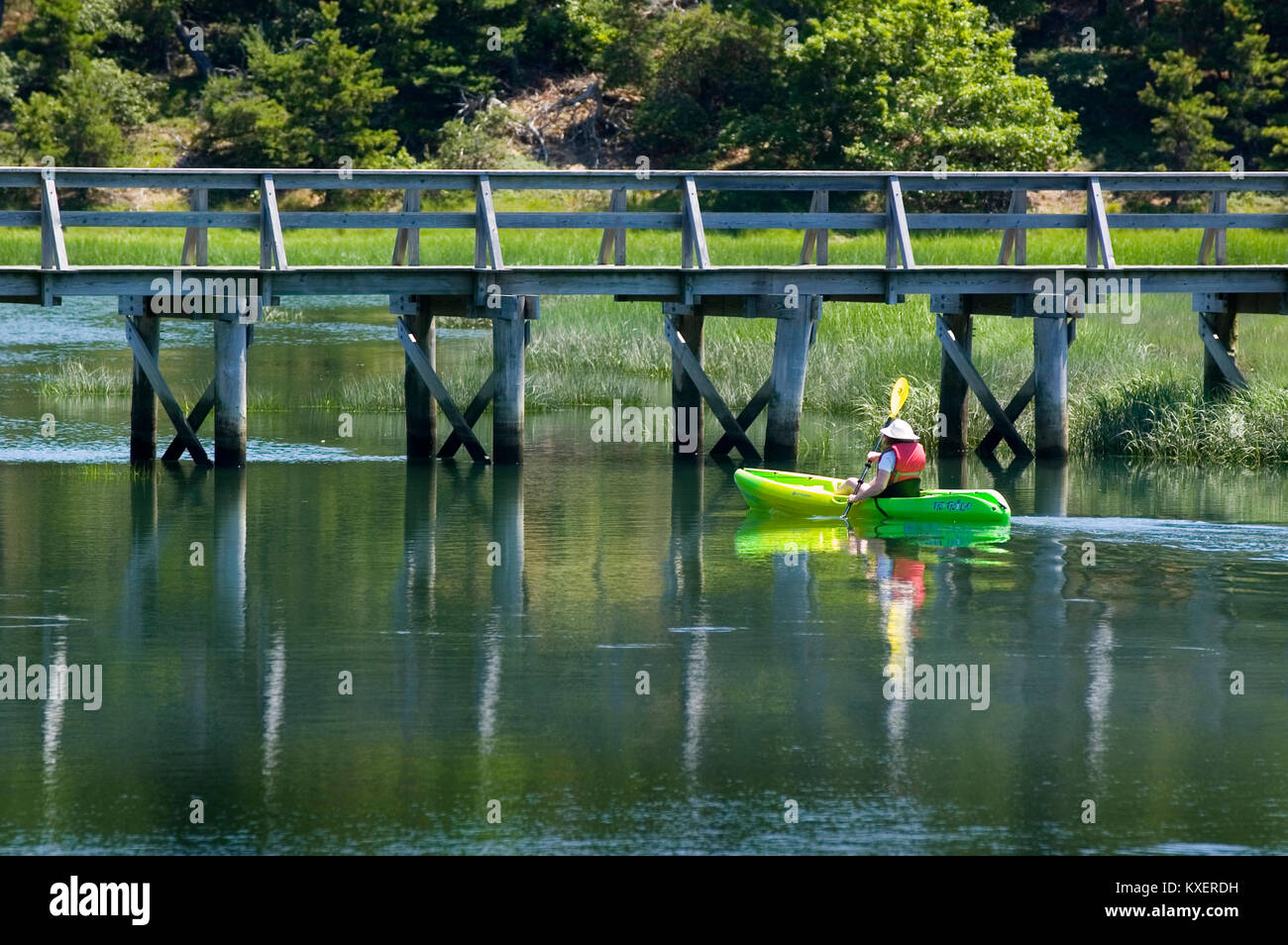 Un Kayakista a punto de pasar bajo el puente cerca del Tío Tim Wellfleet Center en el pantano. Cape Cod, Massachusetts, EE.UU. Foto de stock