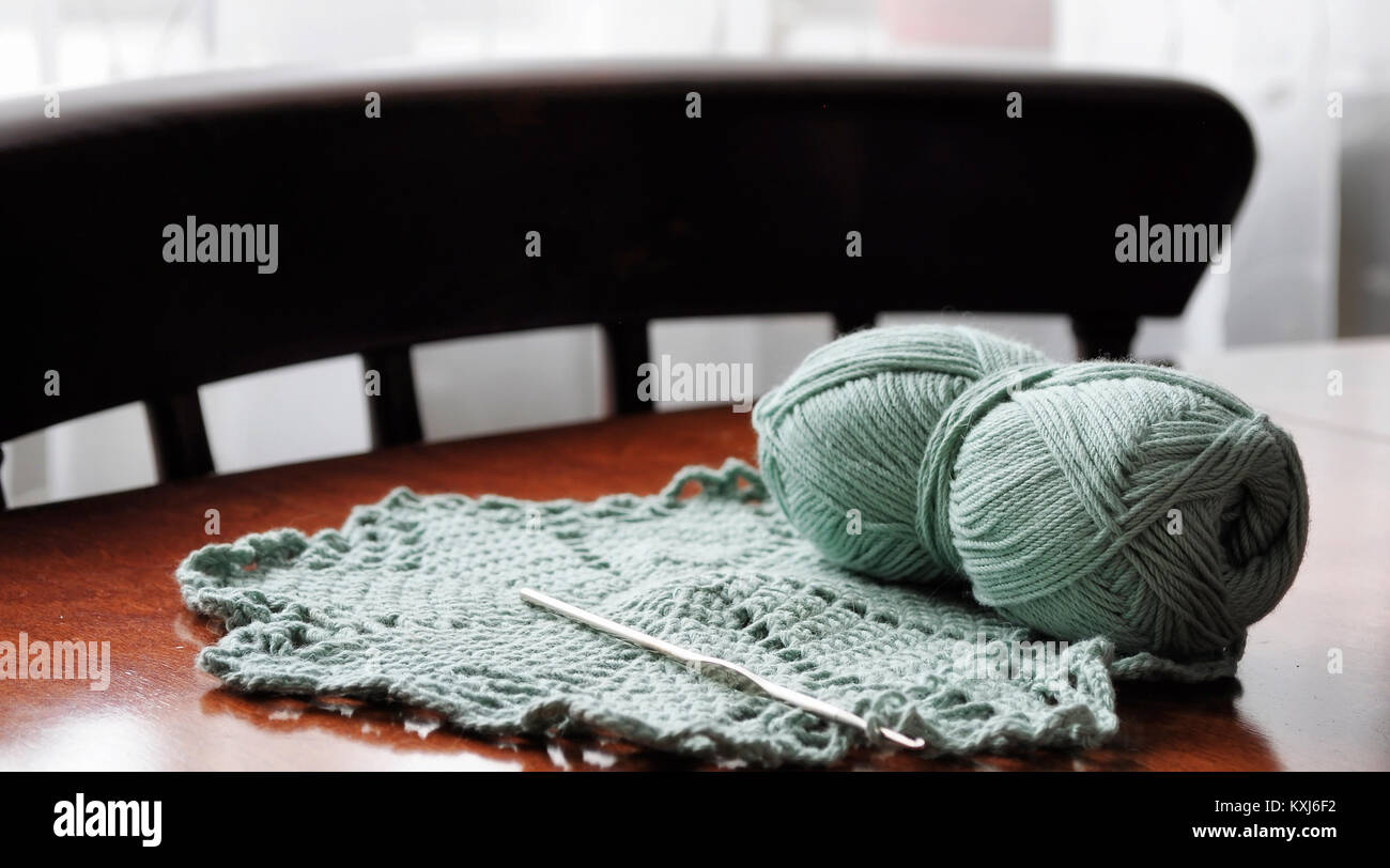 Lana y agujas de tejer en la mesa de la habitación Foto de stock