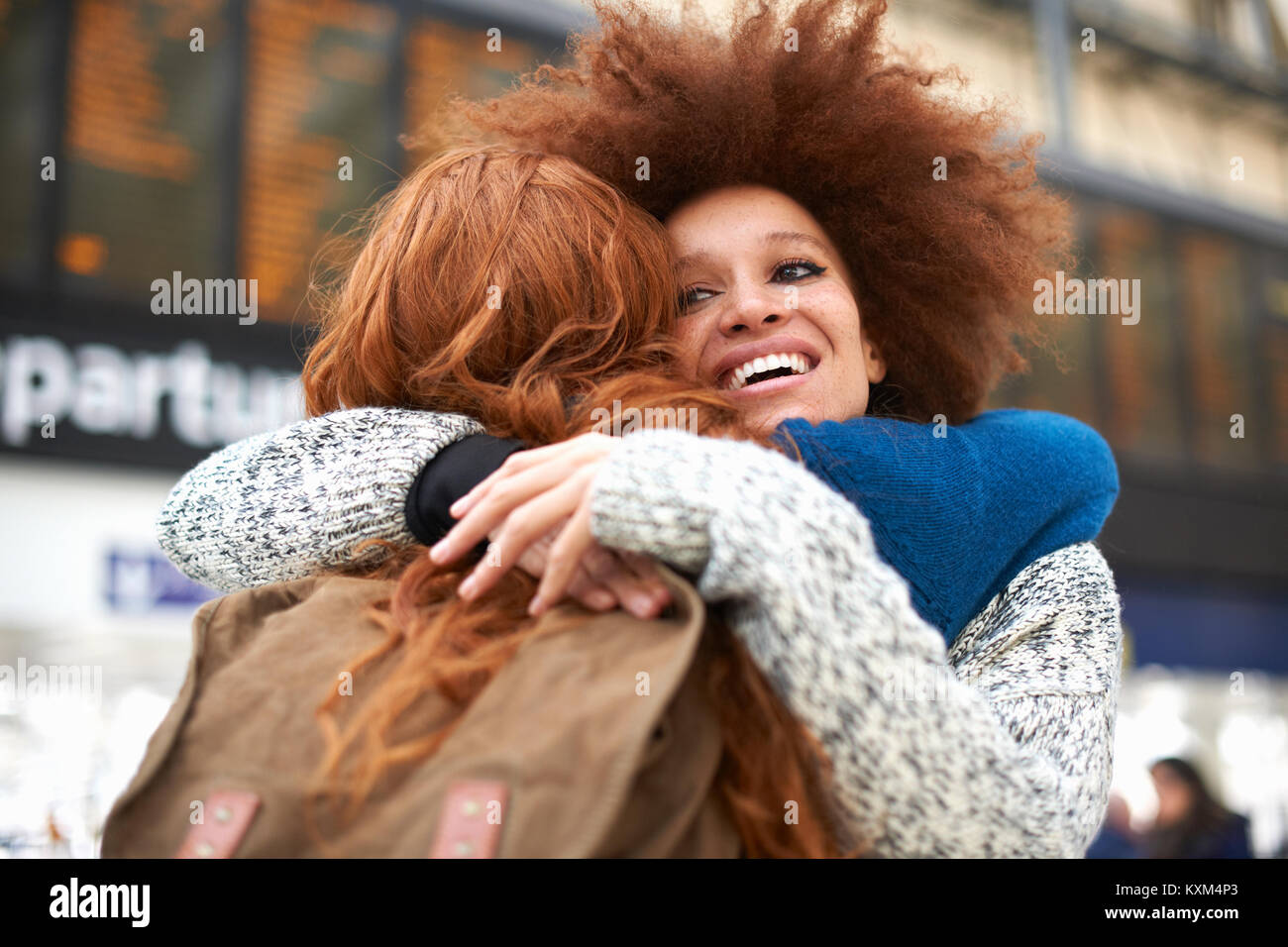 Dos jóvenes mujeres abrazarse en la estación de tren Foto de stock