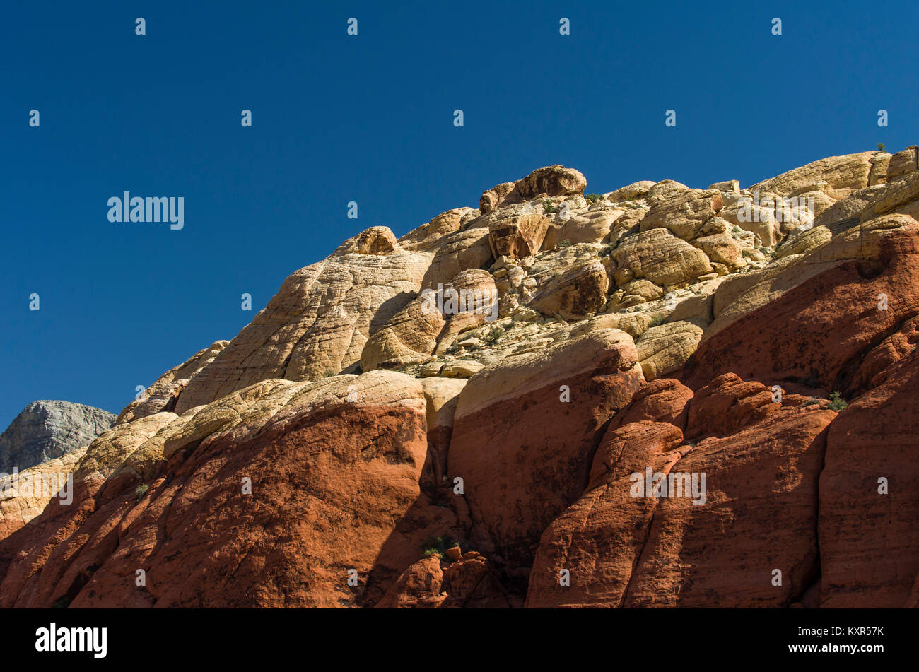 Capas de piedra arenisca de diferentes colores sobre un acantilado rocoso en el Area de Conservación Nacional de Red Rock Canyon. Foto de stock
