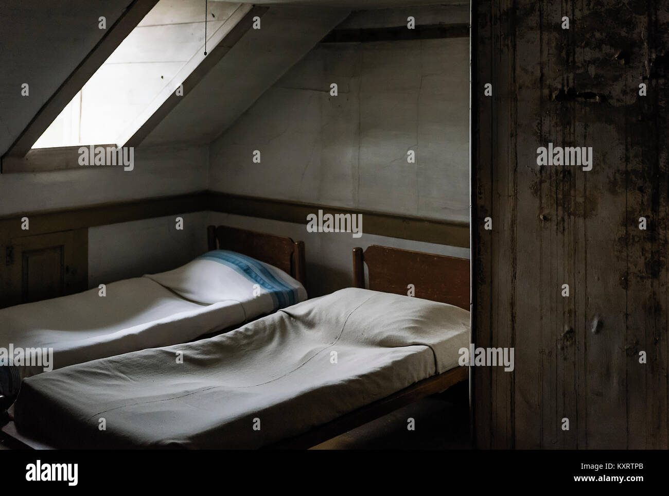 Dormitorio austero con tragaluz. Foto de stock