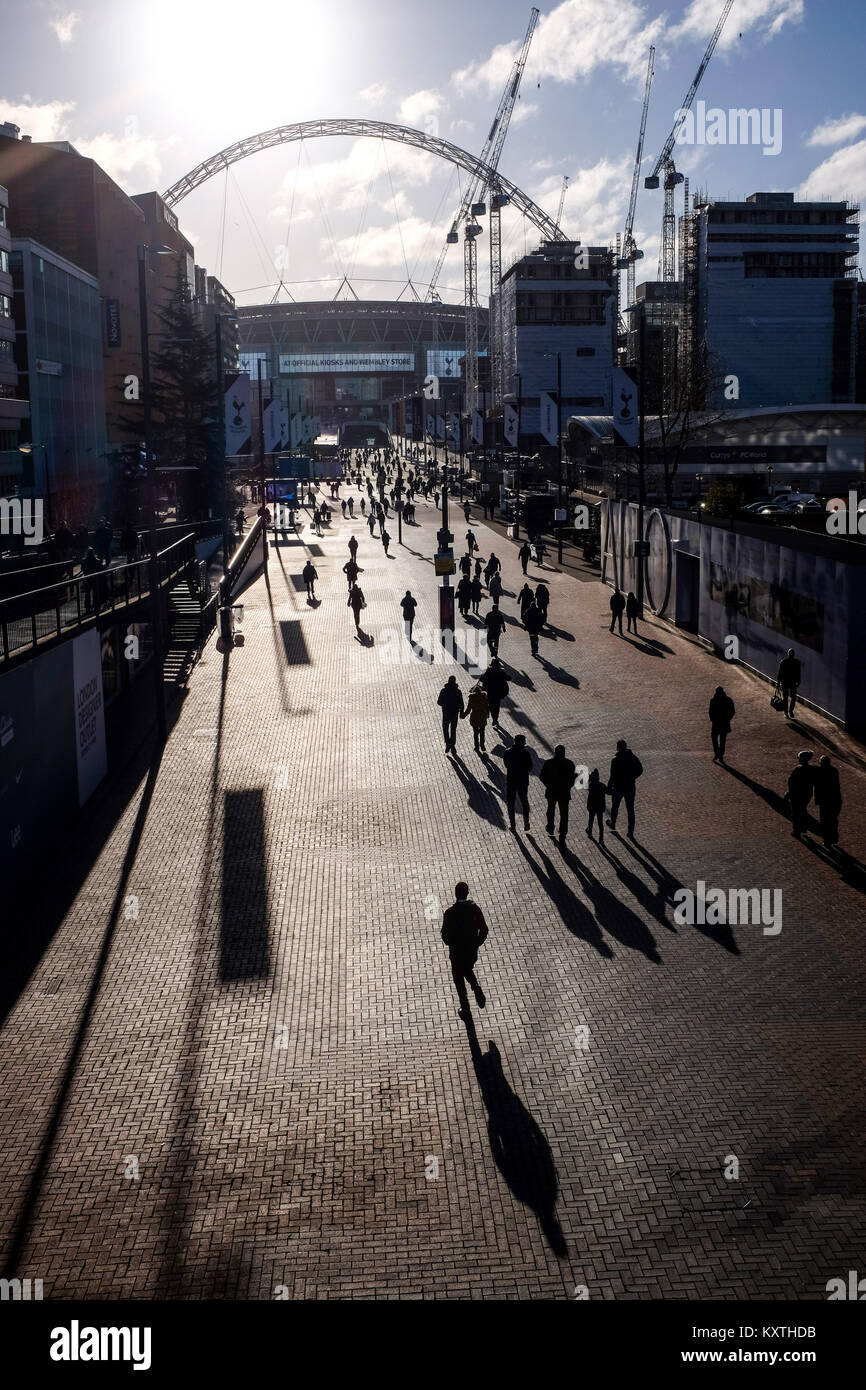 La gente caminando a lo largo de Wembley con largas sombras hacia el estadio de Wembley en Londres . Wembley es el Estadio Nacional de Fútbol de FA en Inglaterra Foto de stock