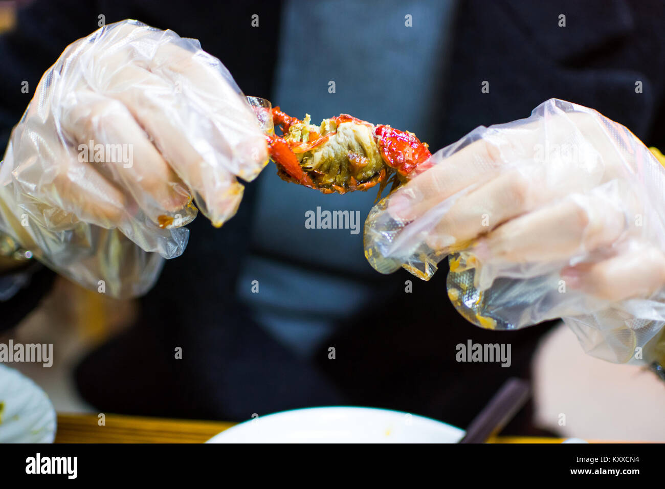Mujer de comer un cangrejo con guantes de plástico cerrar Foto de stock