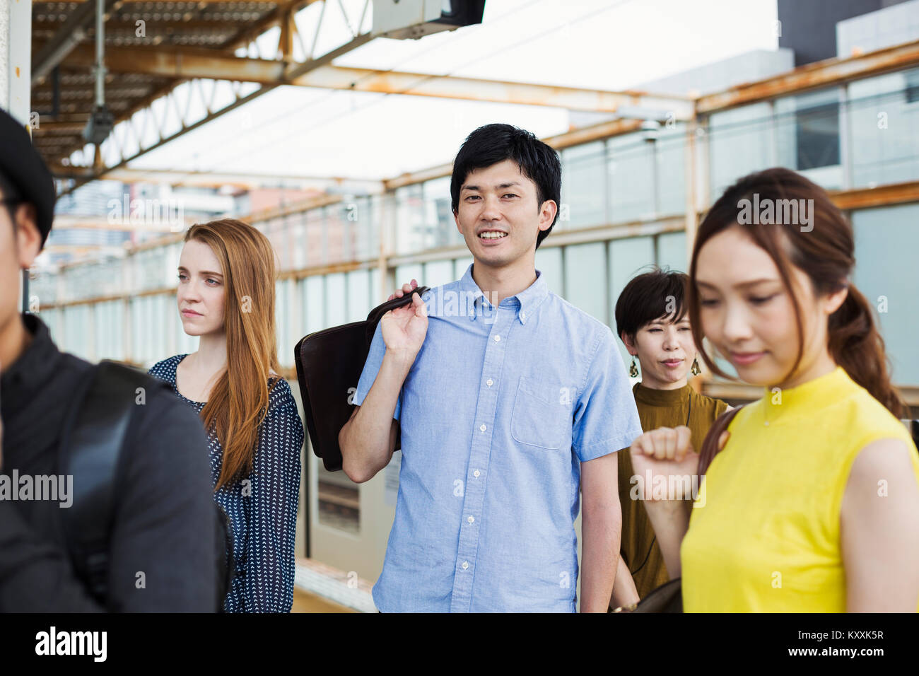 Un pequeño grupo de gente que se encontraba en el andén de una estación de metro, Tokio viajeros. Foto de stock
