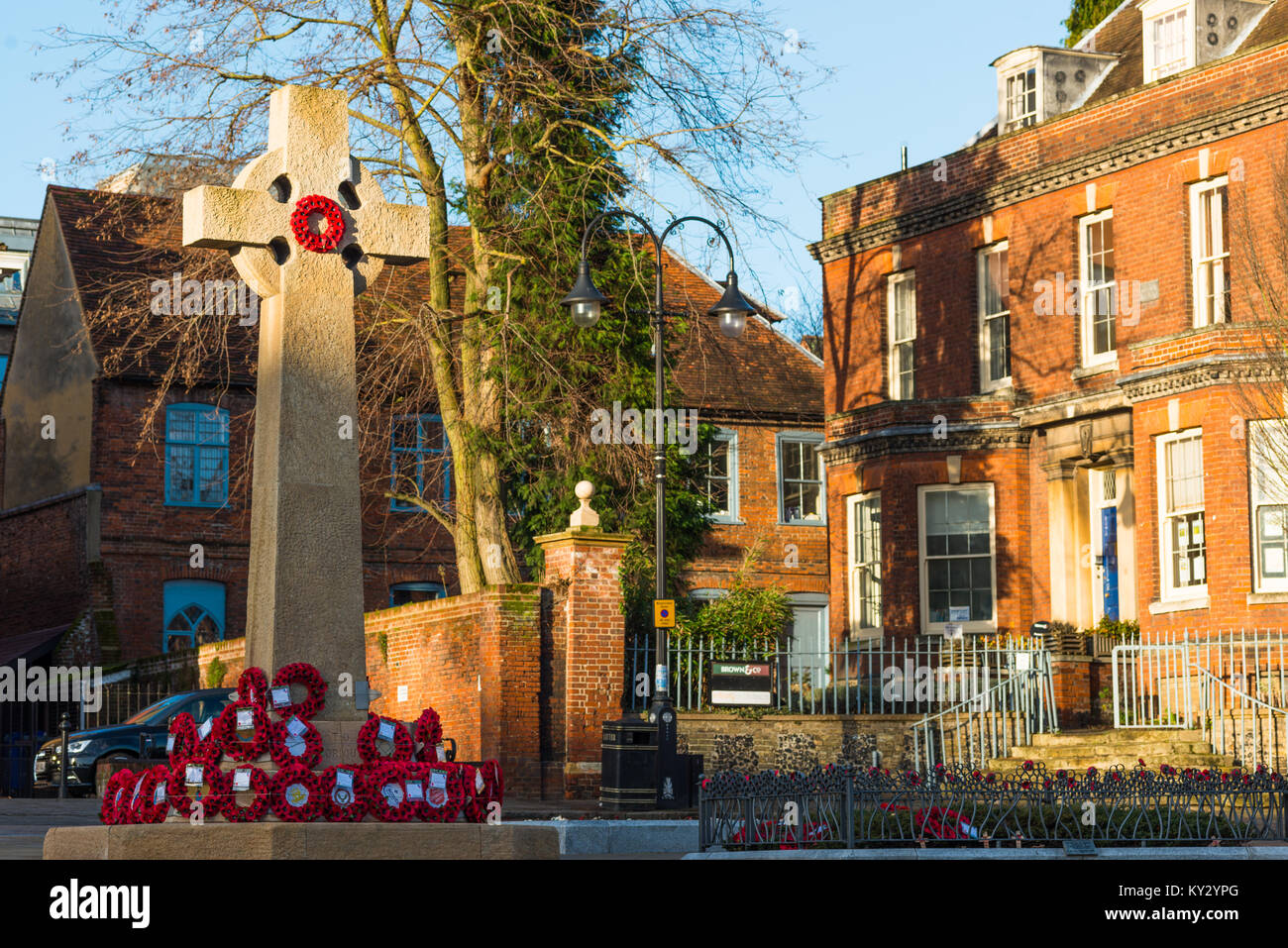 En Bury St Edmunds War Memorial en el Angel Hill - WW1 y WW2 Cruz - con coronas de amapolas. Suffolk, Inglaterra, Reino Unido. Foto de stock