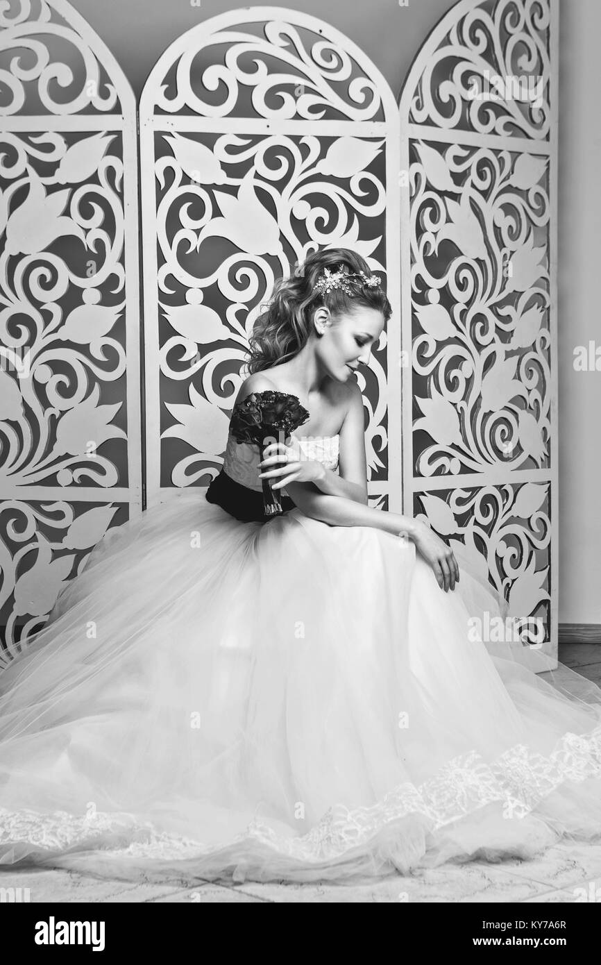 Hermoso cabello rojo joven en blanco vestido de novia con un amplio  cinturón de color púrpura oscuro. novia peinados de moda. Foto de estudio  Fotografía de stock - Alamy