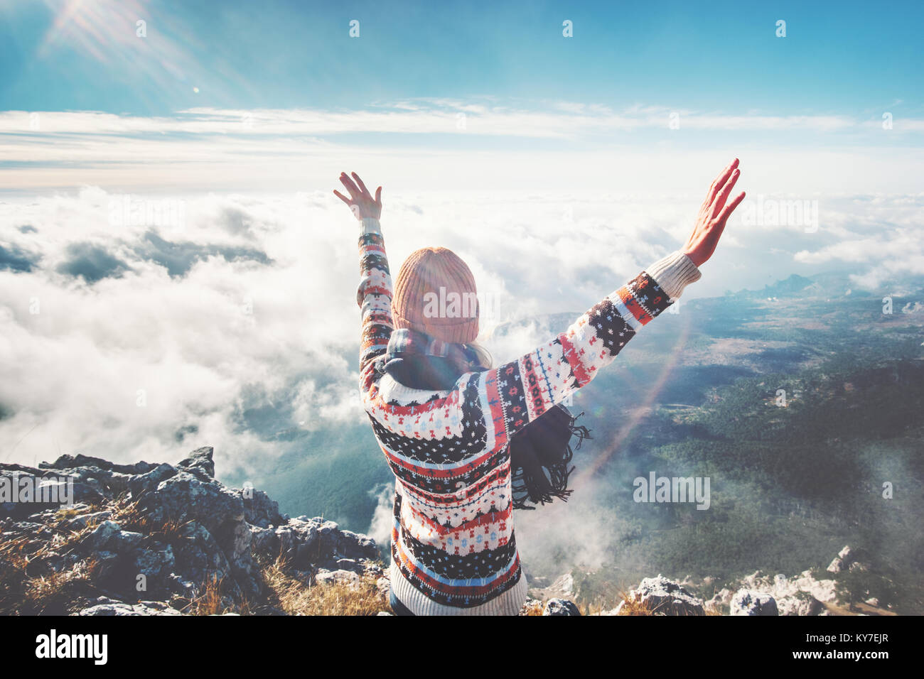 Feliz, la niña en la cumbre de la montaña manos levantadas sobre nubes viajan Lifestyle éxito concepto de aventura al aire libre vacaciones activas Foto de stock