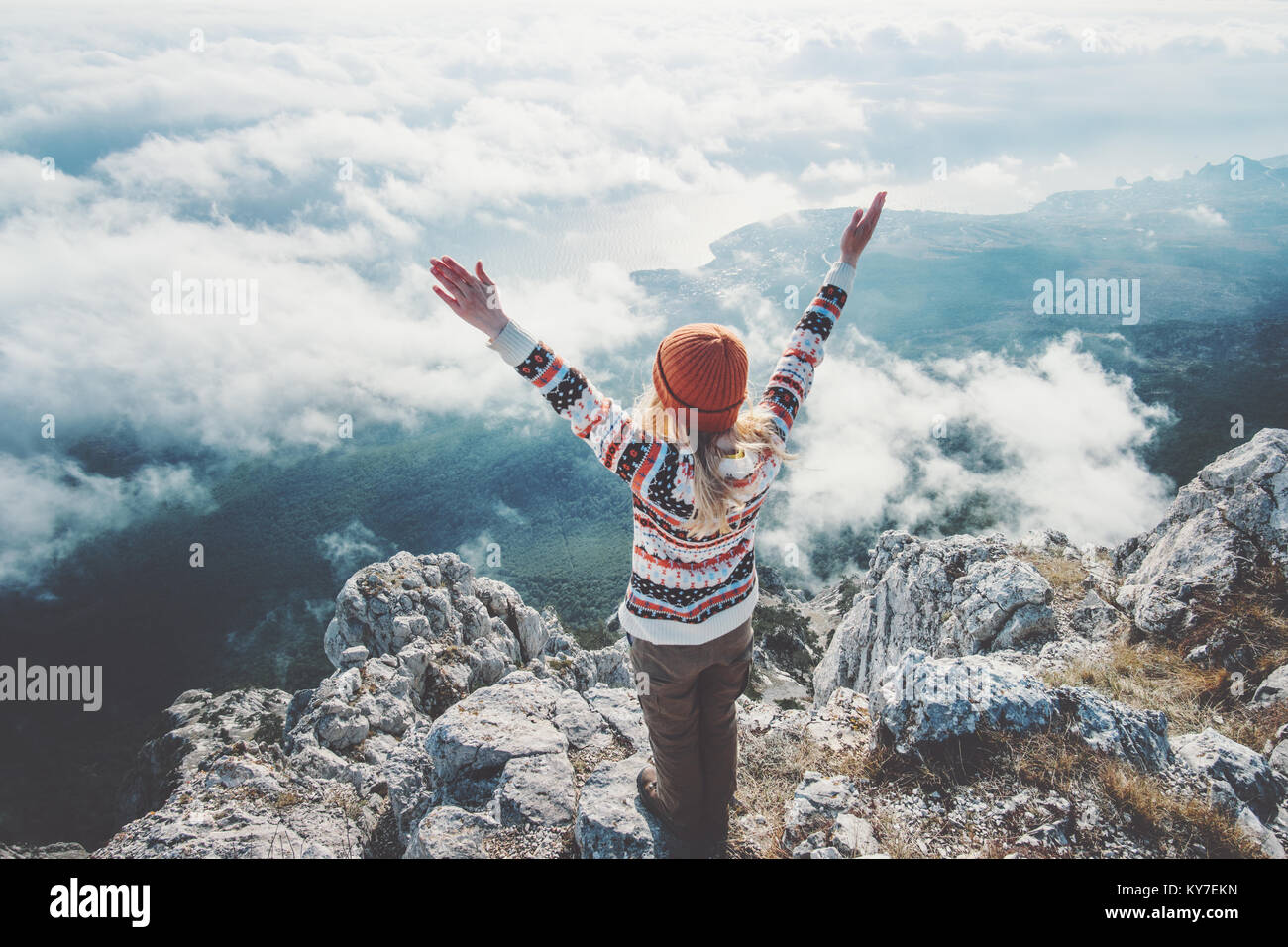 Mujer alegre y viajero de cumbre de montaña manos levantadas sobre nubes viajan Lifestyle éxito concepto de vacaciones activas de aventura outdoor armonía con la natu Foto de stock
