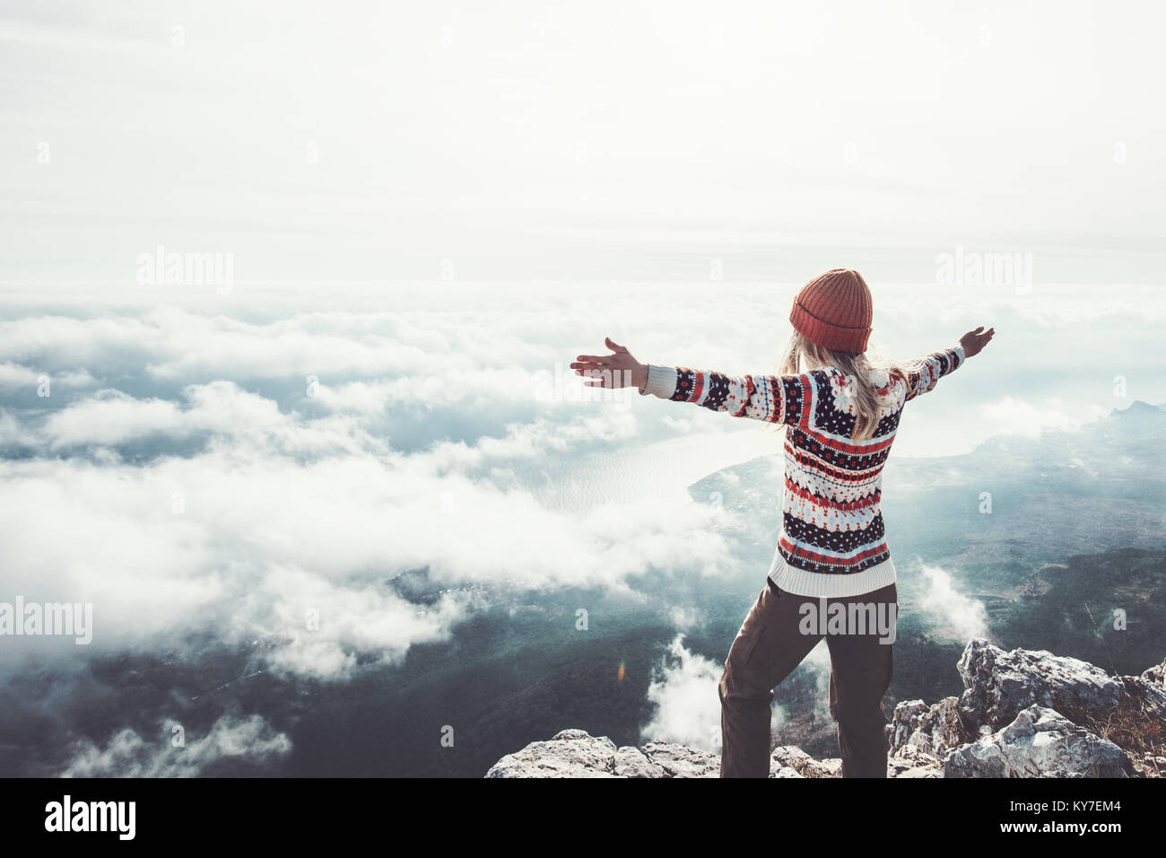 Mujer alegre y viajero de manos levantadas, cumbre de montaña éxito concepto de estilo de vida viajes de aventura al aire libre vacaciones activas sobre nubes armonía con la natu Foto de stock