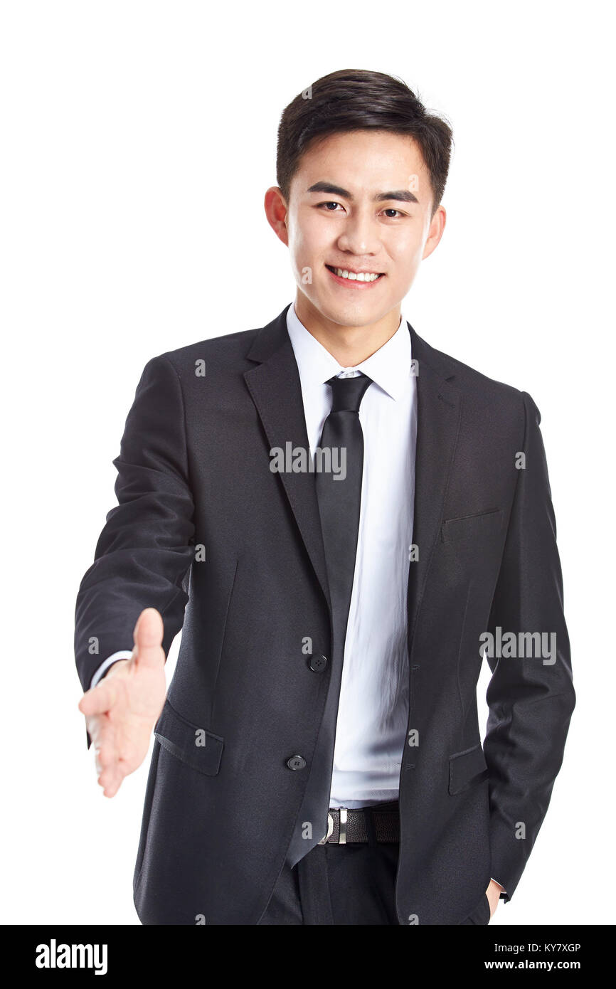 Foto de estudio de un joven empresario asiático llegando por un apretón de manos, mirando a la cámara sonriendo, aislado sobre fondo blanco. Foto de stock