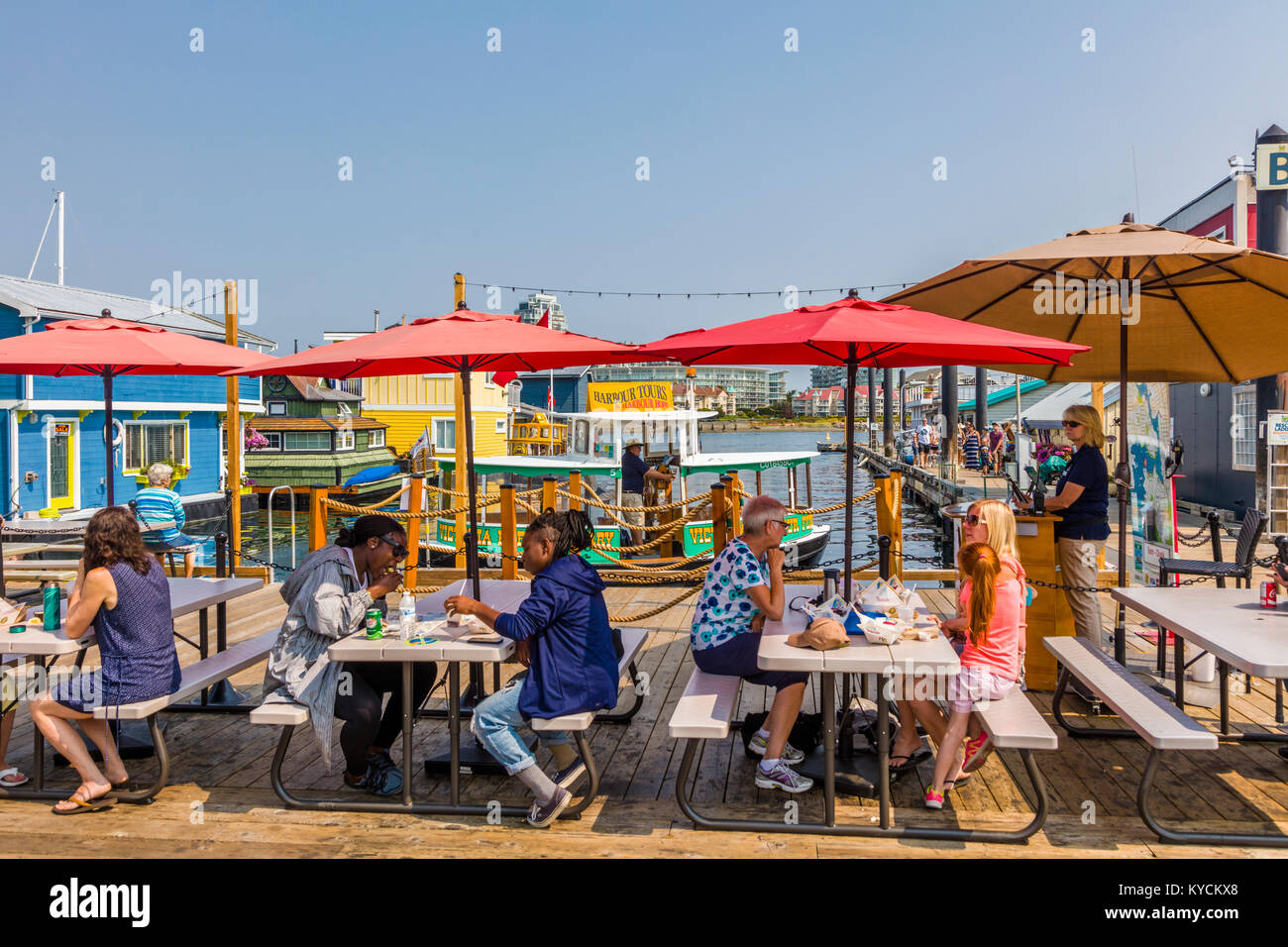 El comedor al aire libre en Fisherman's Wharf en Victoria, Canadá, una atracción turística con quioscos de comida, tiendas y hogares de flotación o houseboats Foto de stock