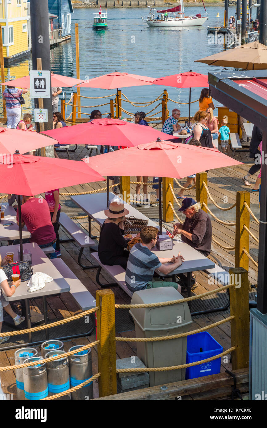 El comedor al aire libre en Fisherman's Wharf en Victoria, Canadá, una atracción turística con quioscos de comida, tiendas y hogares de flotación o houseboats Foto de stock