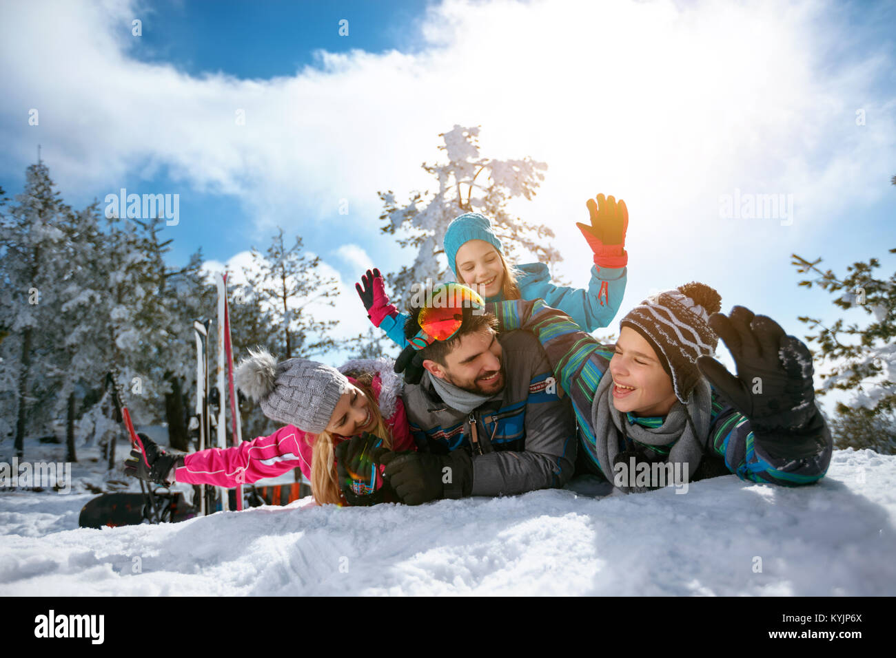Sonriente joven familia en vacaciones de invierno - esquí, nieve, sol y diversión Foto de stock
