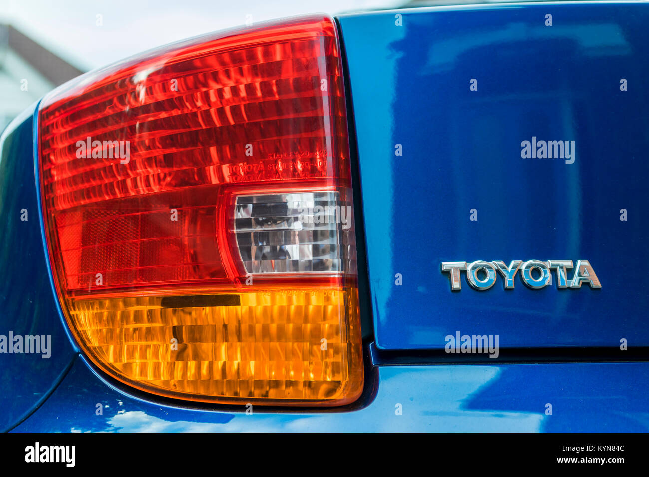 Cerca de una luz trasera de un automóvil Toyota de color azul con la marca/logotipo en letras metálicas Foto de stock