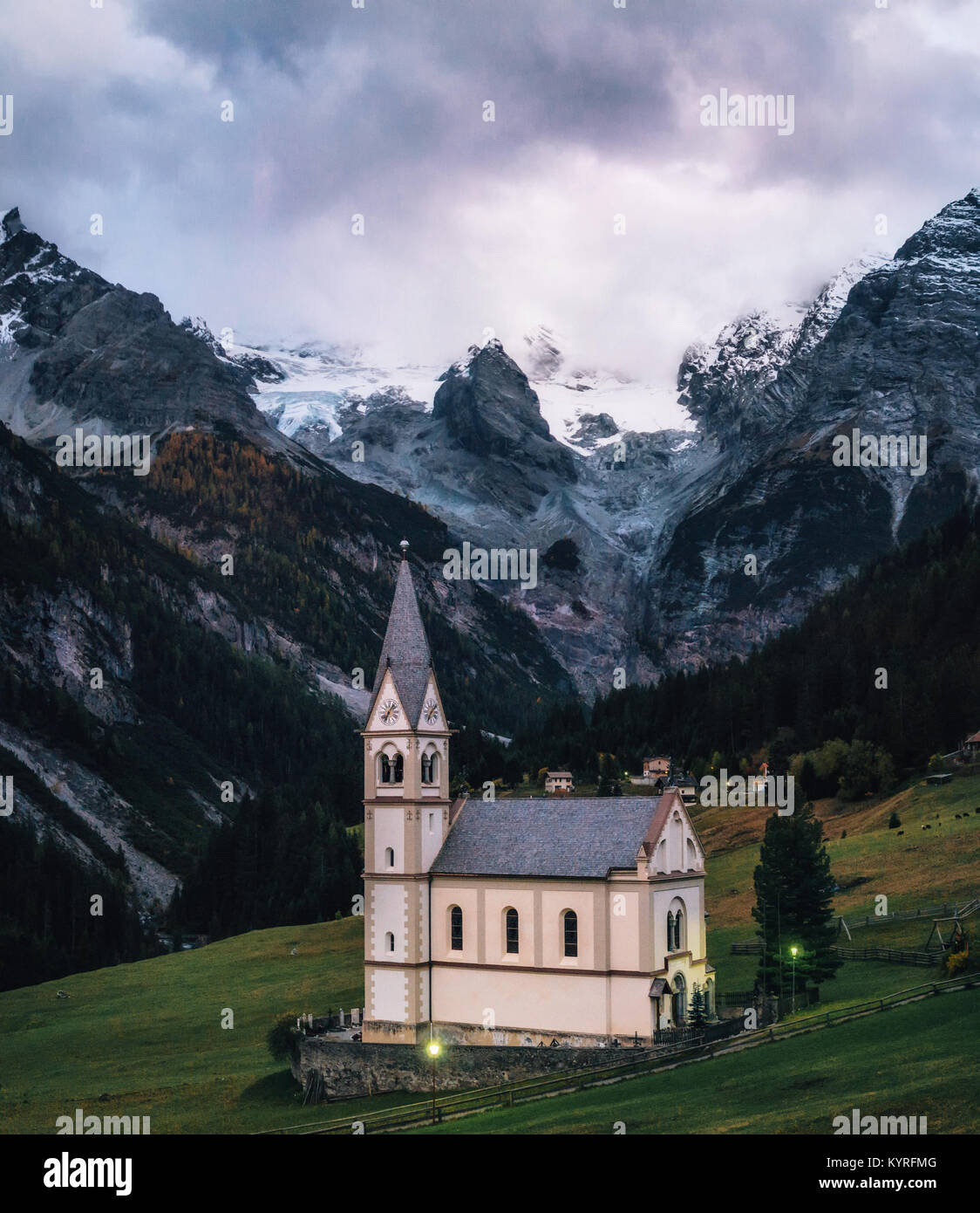Iglesia con torre campanario en Trafoi aldea contra Stelvio montañas en el atardecer, Alpes en Italia Foto de stock
