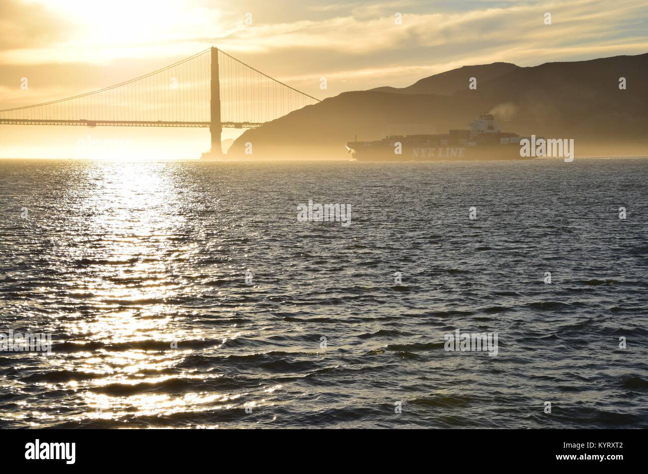 Buque portacontenedores NYK Constelación sale de San Francisco Bay bajo el puente Golden Gate en el atardecer. Foto de stock