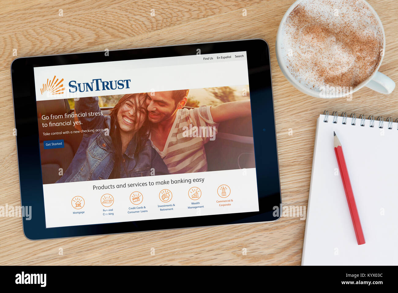 El SunTrust Banks sitio web en un iPad, en una mesa de madera junto a un bloc de notas, lápiz y la taza de café (Editorial) Foto de stock