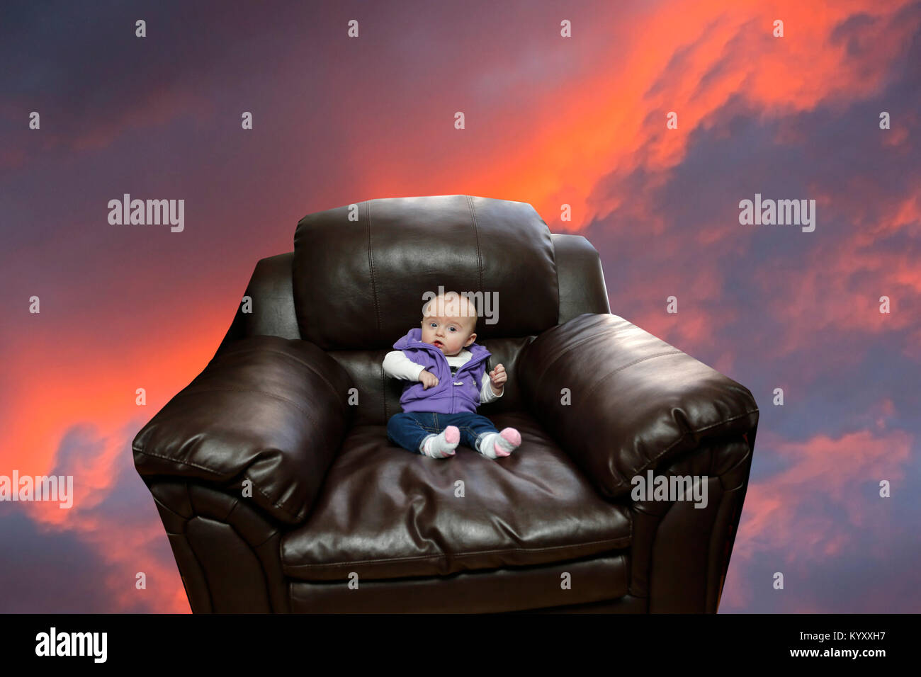 Niña sentada en un sillón sobredimensionado buscando interesados Foto de stock