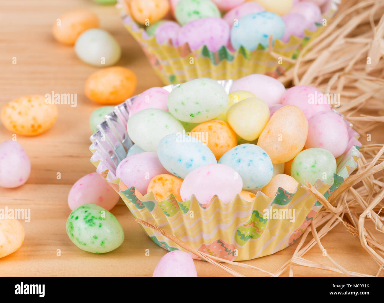 Pascua coloridos Jelly Beans en tazas de papel sobre un fondo de madera Foto de stock
