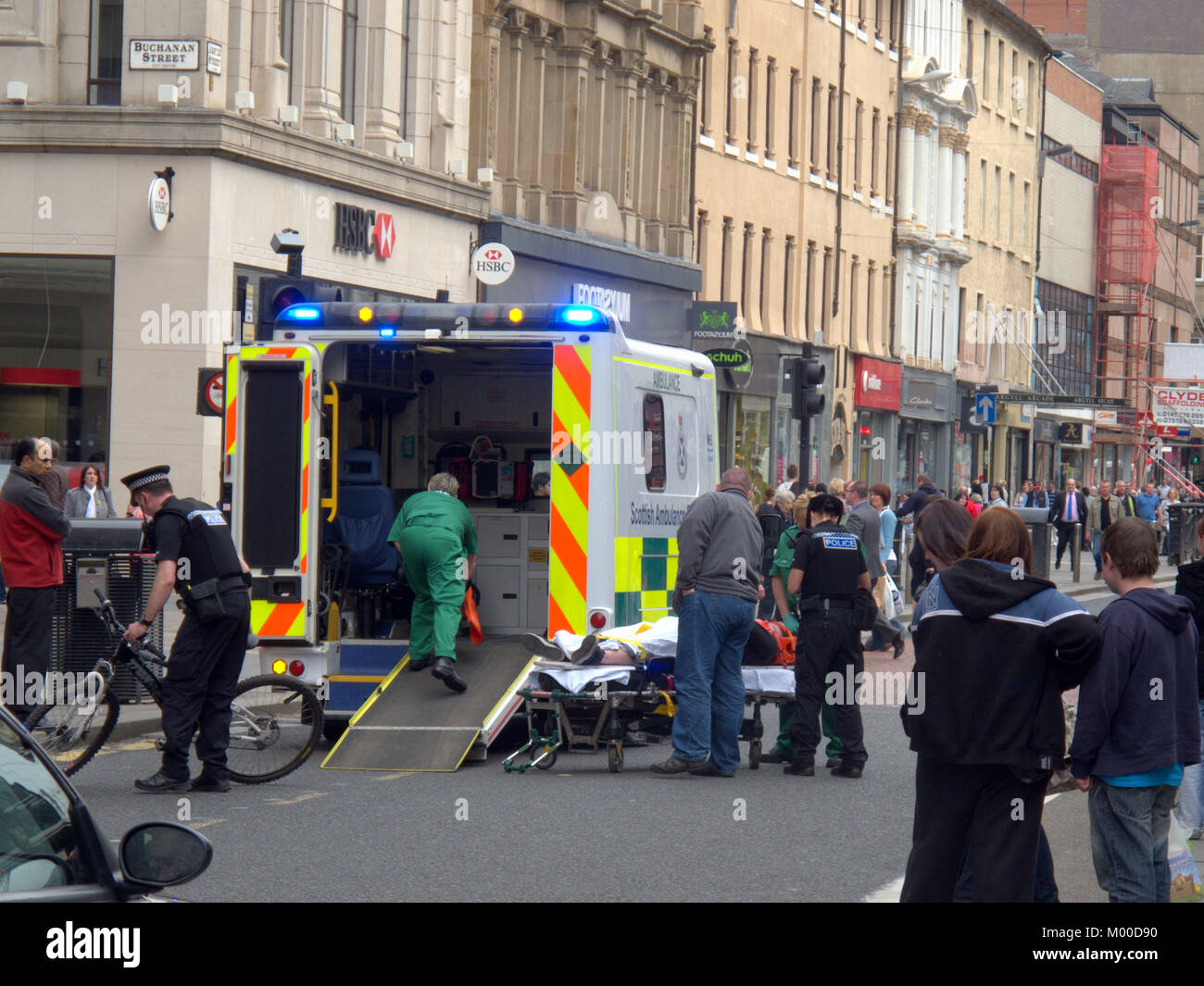 Ciclista lesionado con bicicleta se ponga en la parte trasera de la ambulancia con la policía y la tripulación en presencia, en Argyle street Glasgow Foto de stock