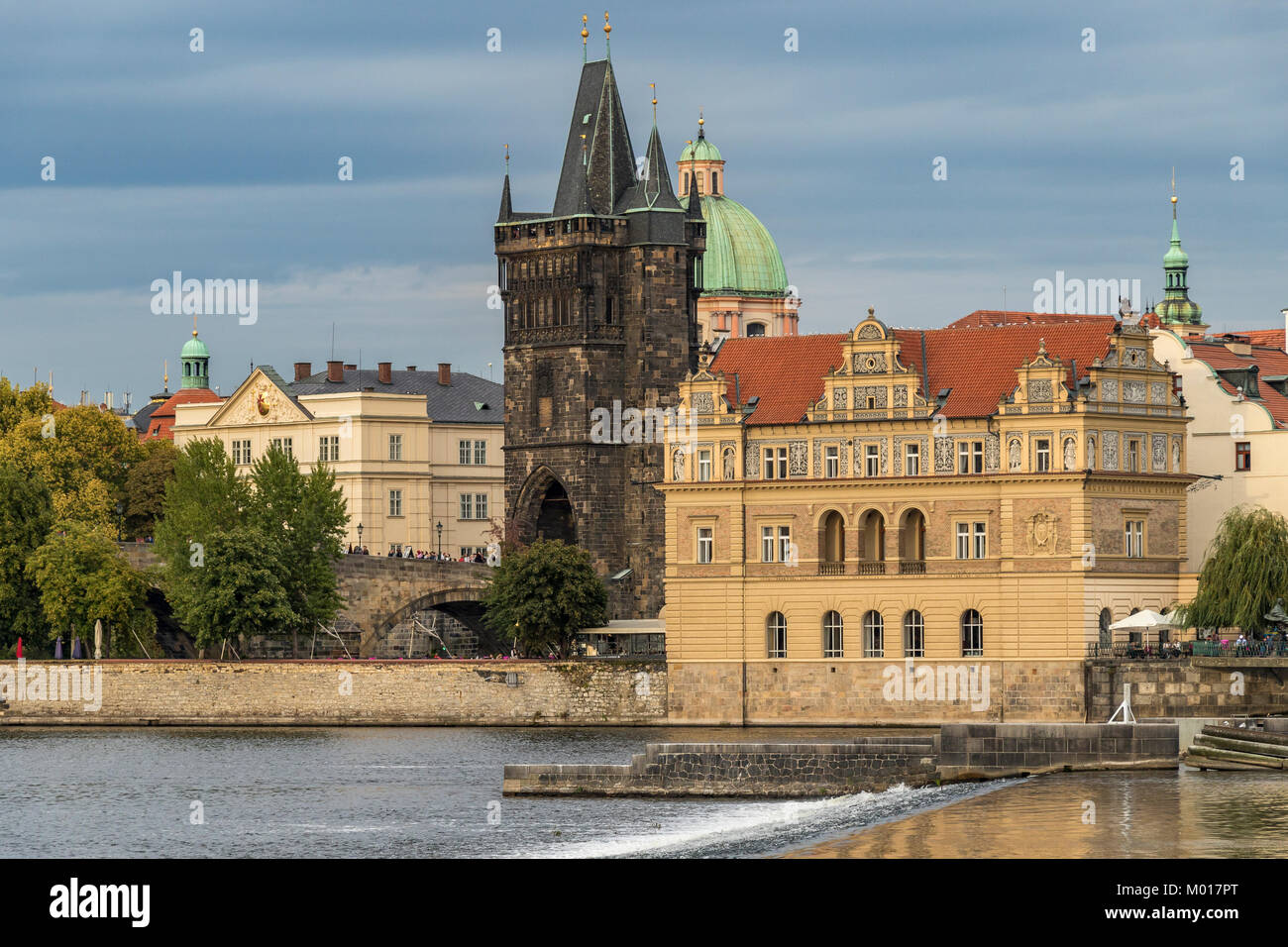 La Ciudad Vieja de Praga y el Puente de Carlos con la Torre del Puente de la Ciudad Vieja vista desde las orillas del río Vlatava bañado en la luz del sol por la tarde Foto de stock